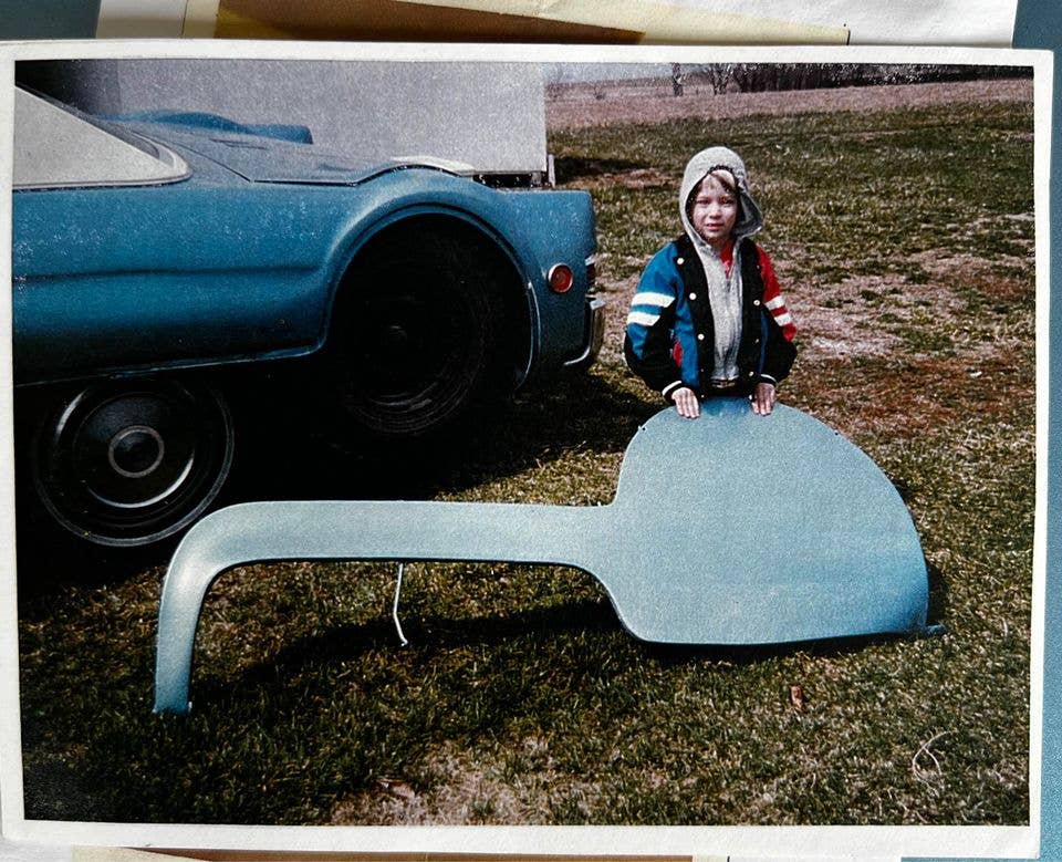 Nedatovaná fotografie dítěte držícího kryt Buicku na jeho třetí nápravě