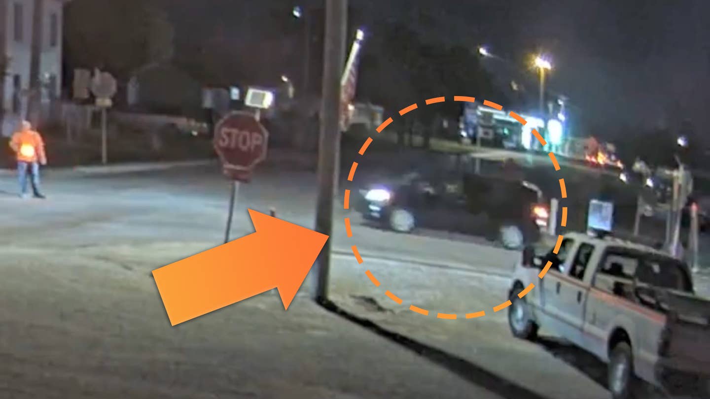 An unidentified black minivan is circled crossing an intersection at night