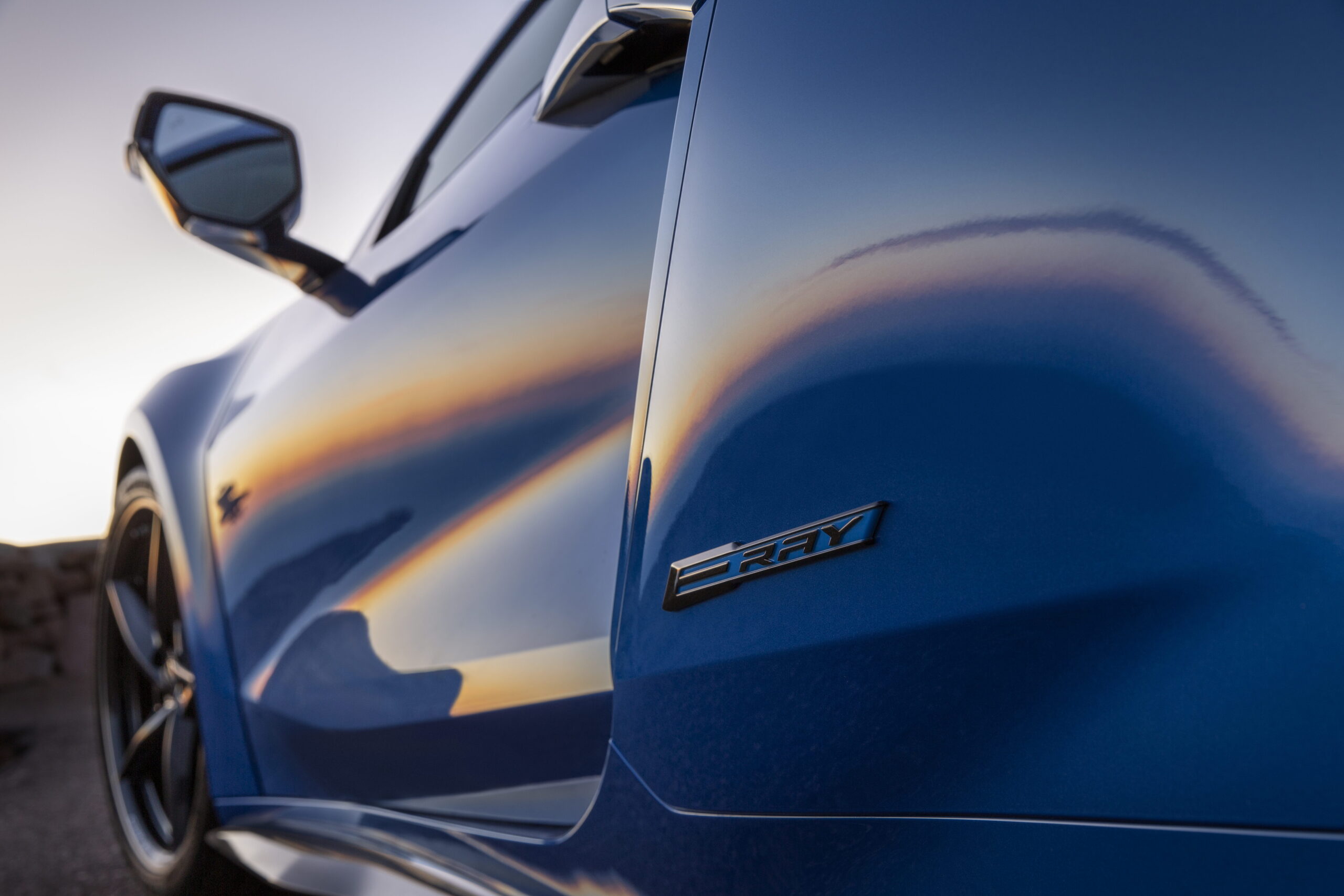 Close-up of the E-Ray badge on a 2024 Corvette E-Ray 3LZ coupe in Riptide Blue Metallic. Pre-production model shown. Actual production model may vary. Model year 2024 Corvette E-Ray available 2023.