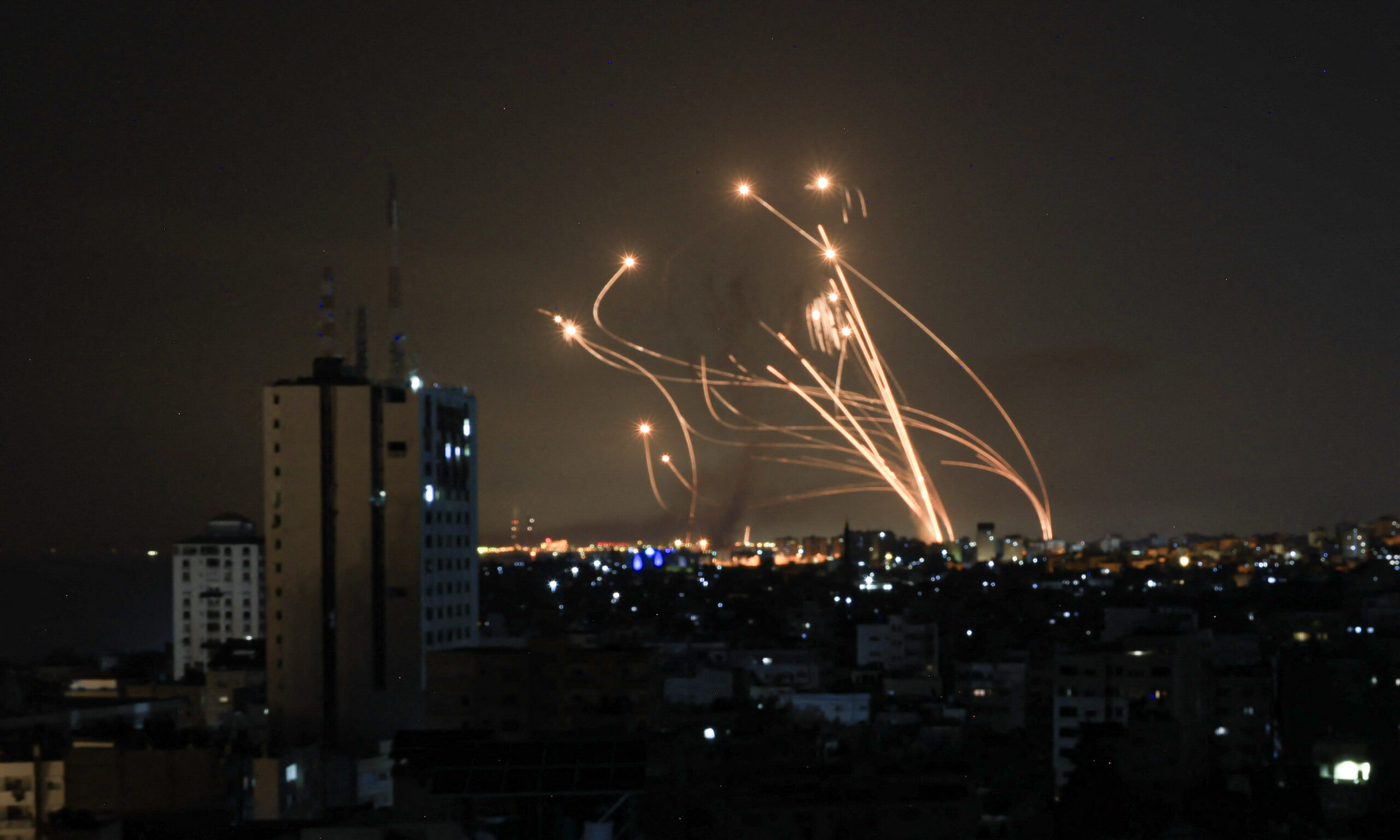 An Israeli missile launched from the Iron Dome defence missile system attempts to intercept a rocket, fired from the Gaza Strip, over the city of Netivot in southern Israel on October 8, 2023. Israel, reeling from the deadliest attack on its territory in half a century, formally declared war on Hamas Sunday as the conflict's death toll surged close to 1,000 after the Palestinian militant group launched a massive surprise assault from Gaza. (Photo by MAHMUD HAMS / AFP) (Photo by MAHMUD HAMS/AFP via Getty Images)