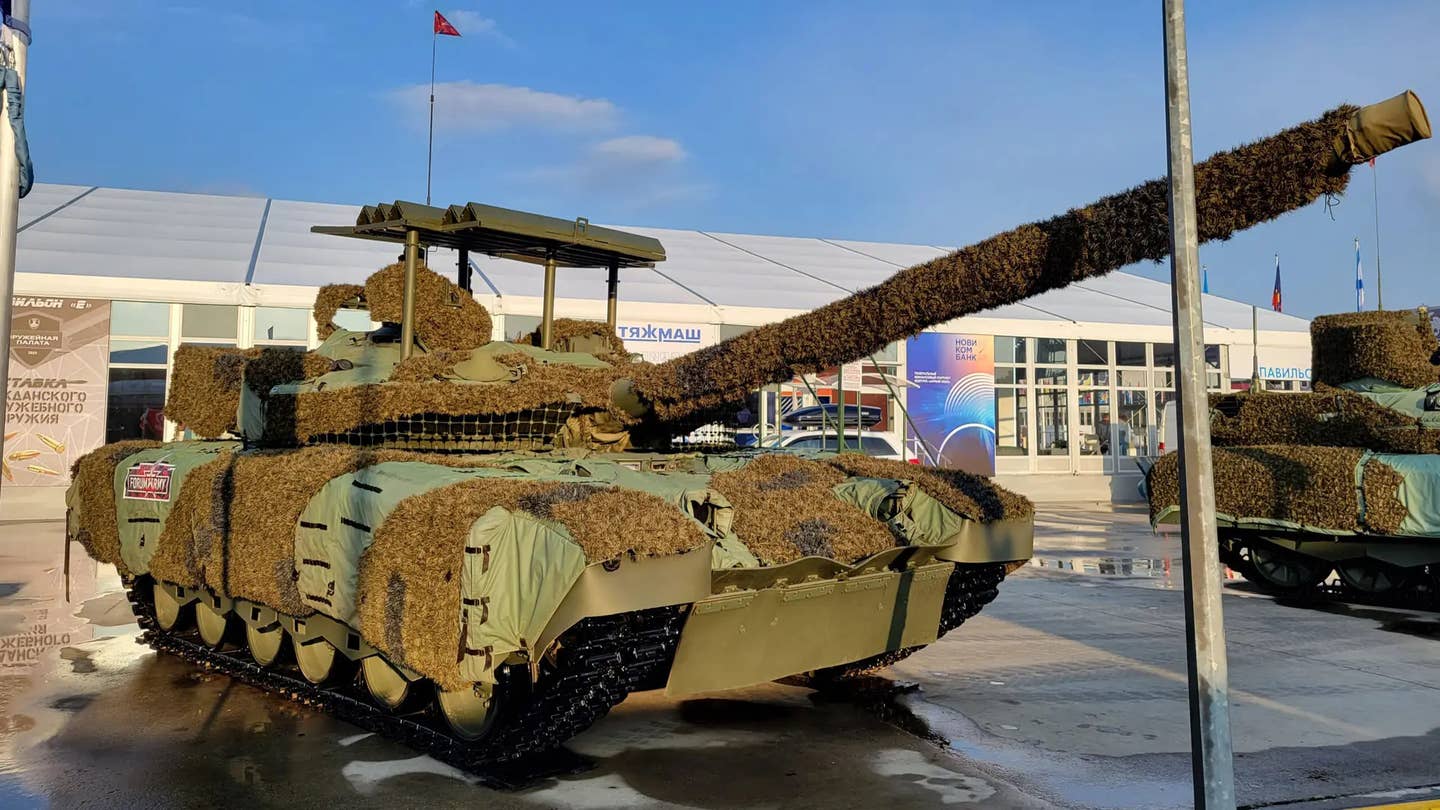 A Russian T-80BVM tank with factory-made 'cope cage' style armor on display at the Army-2023 defense exhibition in August 2023. <em>Michael Jerdev/@MuxelAero</em>