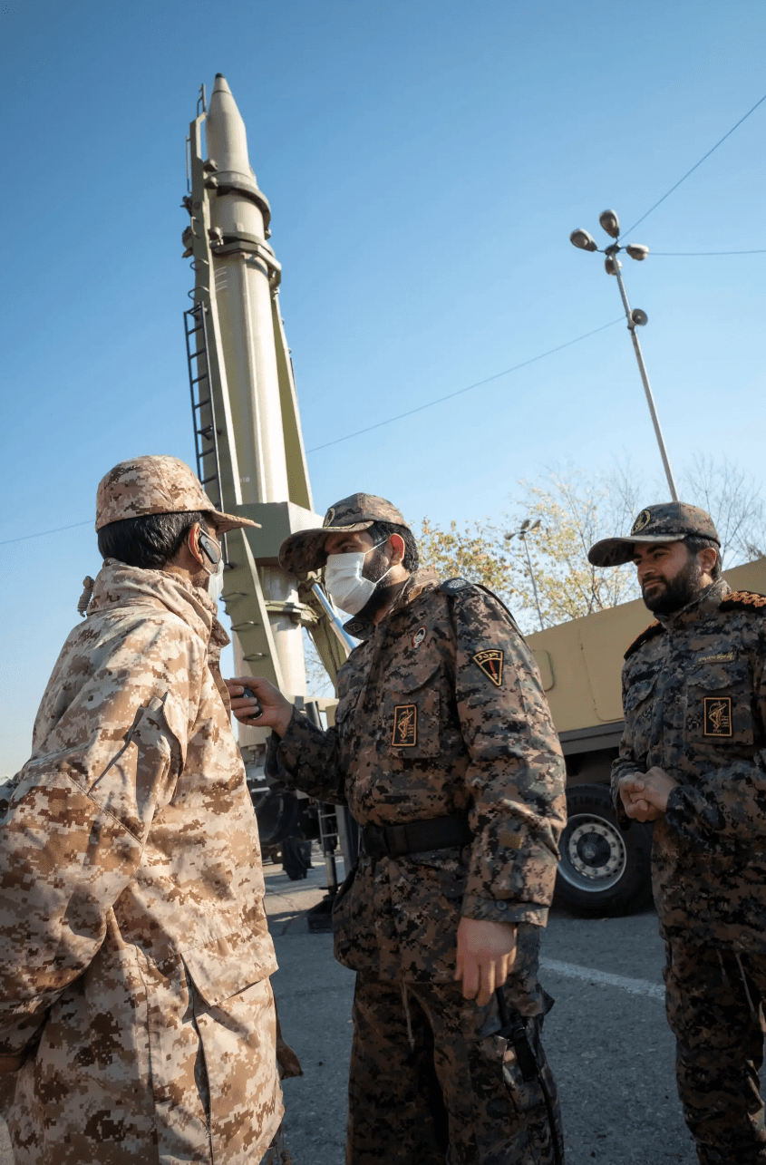 Iranian Islamic Revolutionary Guard Corp military personnel talk as a Qiam short-range ballistic missile is displayed in a military exhibition to mark the anniversary of the Iran missile attack on Al-Assad Air Base in Iraq. <em>Photo by Morteza Nikoubazl/NurPhoto via Getty Images</em>