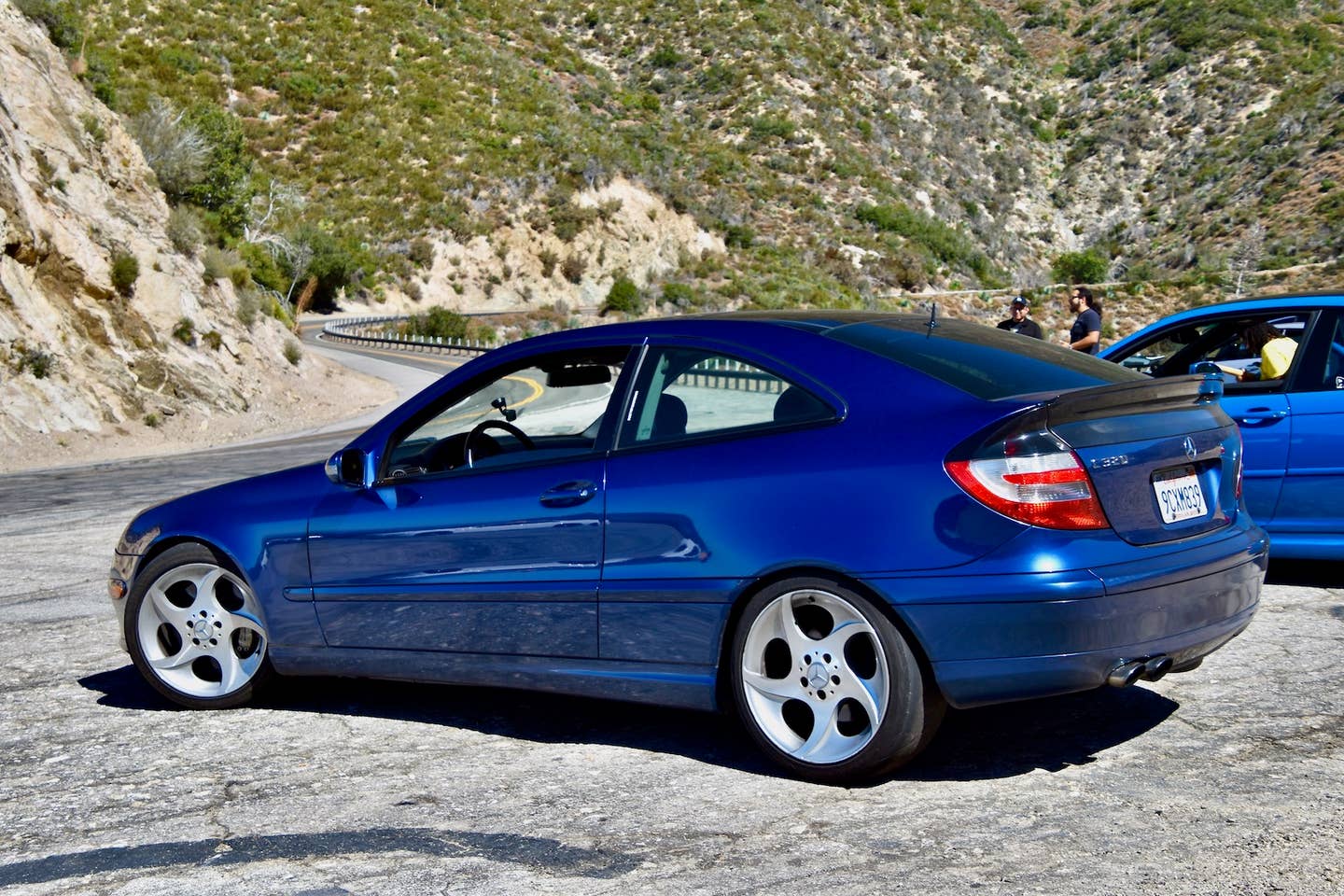 Modrý Mercedes C320.  Má fastback linii střechy, dvoje dveře a krátký rozvor.