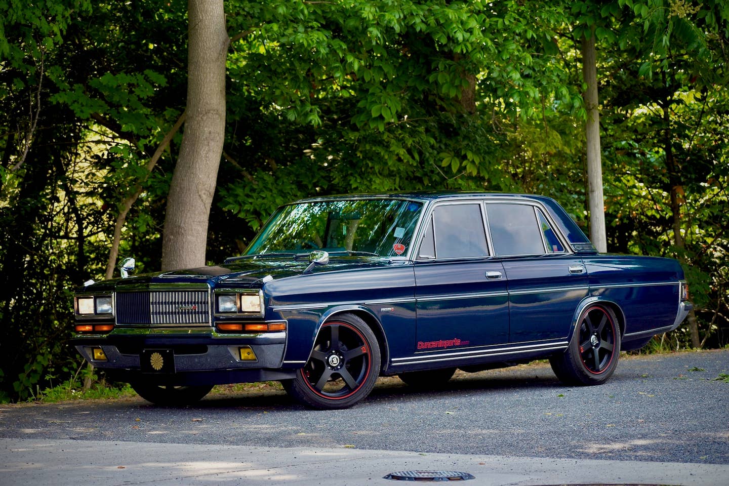 1989 Nissan President against a forested backdrop