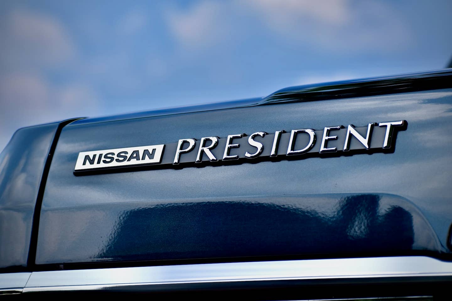 Odznak na víku zavazadlového prostoru Nissan President z roku 1989