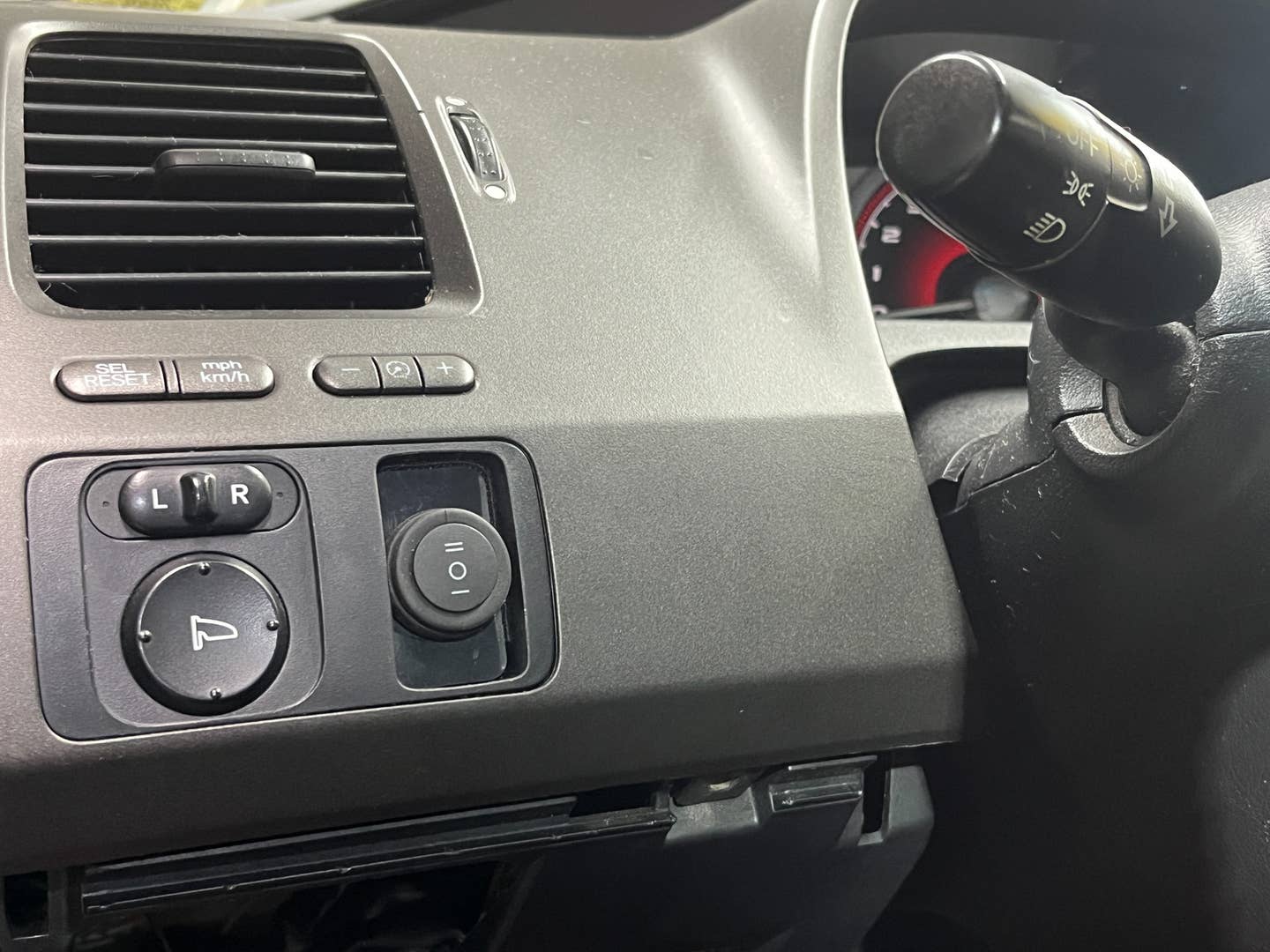 The partially recessed blank panel makes the large toggle tuck into the Civic's dashboard a little neatly. <em>Andrew P. Collins</em>
