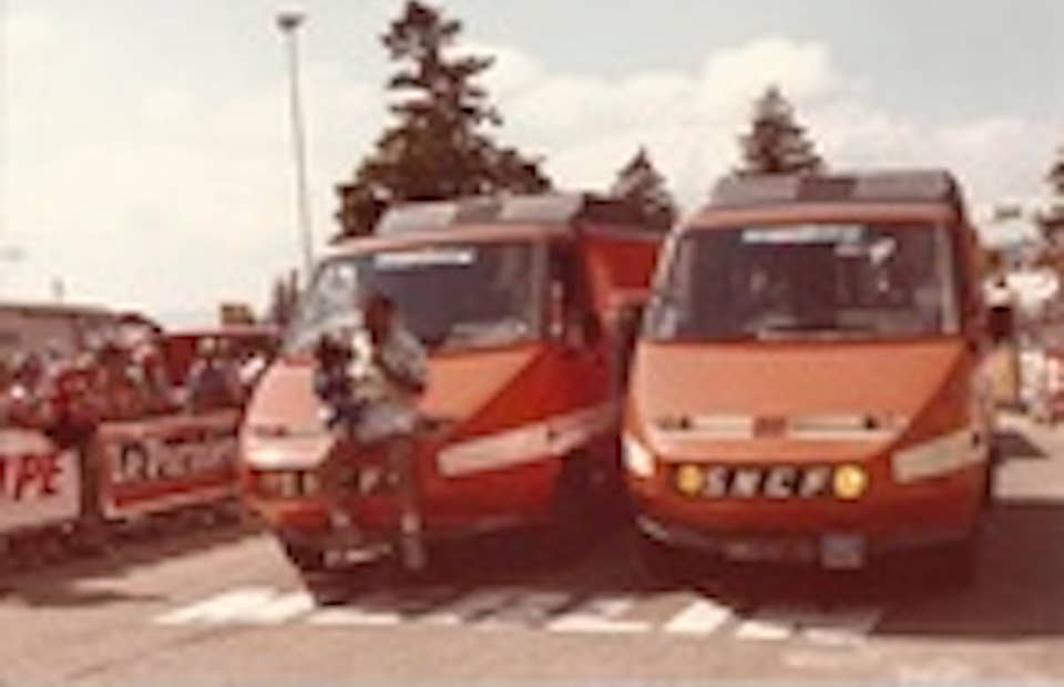 An unknown individual rides on the front of the TGV vans