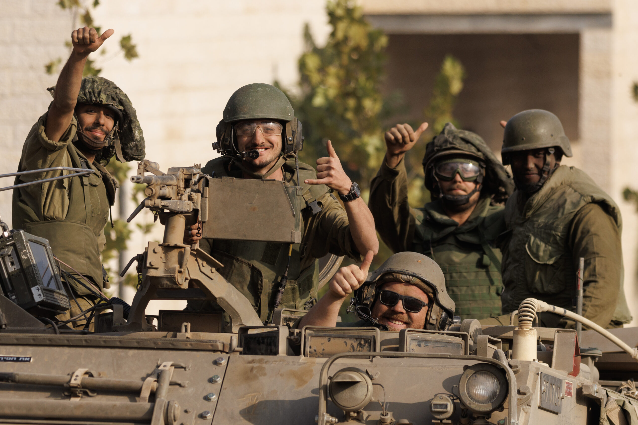 SDEROT, ISRAEL - OCTOBER 28: Israeli soldiers give a thumbs-up gesture as Israeli troops move near the border with Gaza on October 28, 2023 in Sderot, Israel. In the wake of the Oct. 7 attacks by Hamas that left 1,400 dead and 200 kidnapped, Israel launched a sustained bombardment of the Gaza Strip and threatened a ground invasion to vanquish the militant group that governs the Palestinian territory. But the fate of the hostages, Israelis and foreign nationals who are being held by Hamas in Gaza, as well as international pressure over the humanitarian situation in Gaza, have complicated Israel's military response to the attacks. A timeline for a proposed ground invasion remains unclear. (Photo by Dan Kitwood/Getty Images)