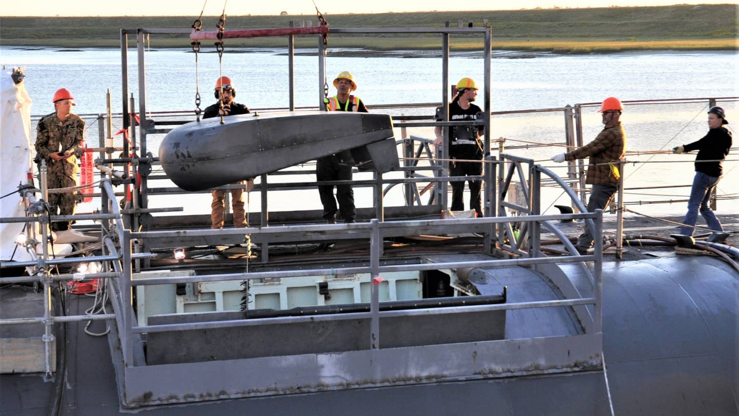 A wider shot of the buoy being hoisted out of its compartment on the Ohio class ballistic missile submarine USS <em>Tennessee</em> during the recent post-repair test. The bay doors are also visible here. <em>USN</em>