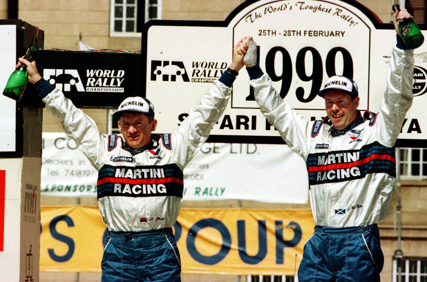 Ford co-driver Nicky Grist and driver Colin McRae stand on the top step of the podium after winning the 1999 Safari Rally, the first for the Focus WRC. The car proved fast but unreliable in its inaugural season.