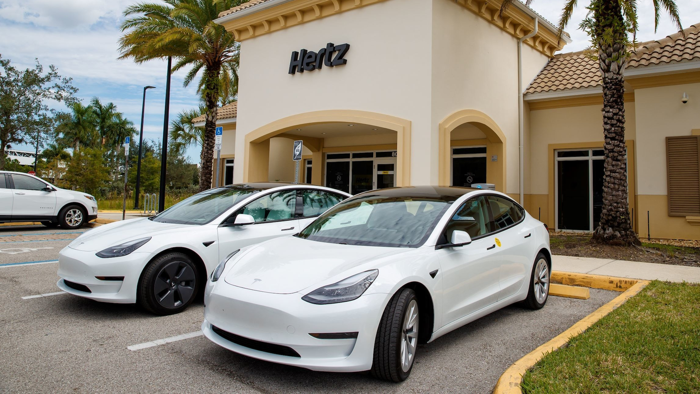 Tesla Model 3s parked at a Hertz car rental office