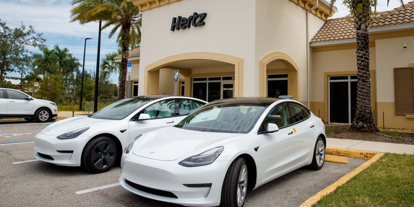 Tesla Model 3s parked at a Hertz car rental office