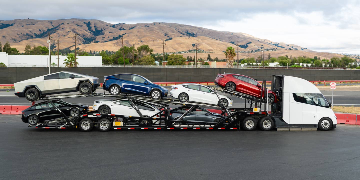 A car trailer with several Teslas on it