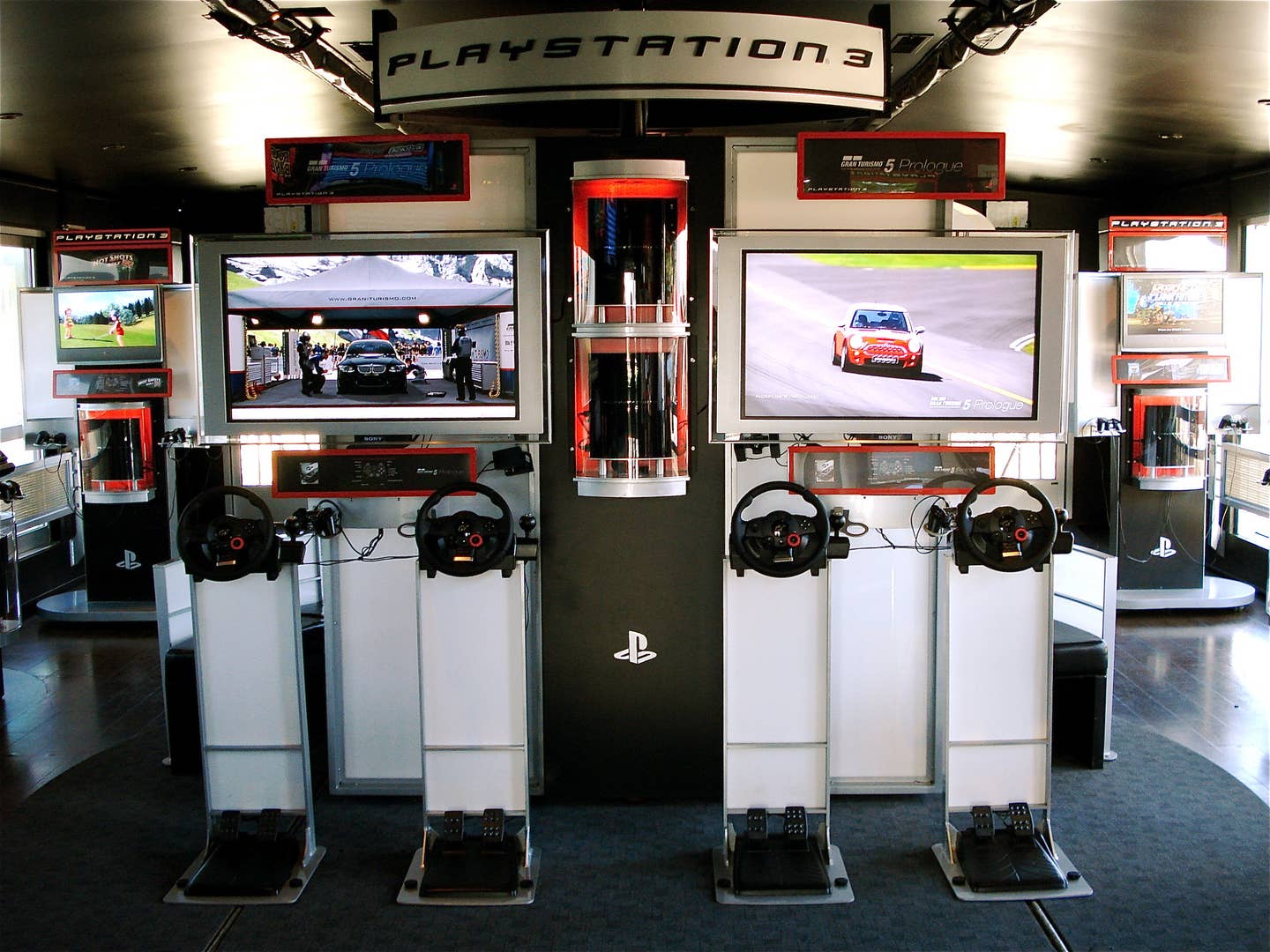 A photo of a PlayStation Experience truck back when it was demoing Gran Turismo 5 Prologue, with what looks to be a very uncomfortable standing rig setup.