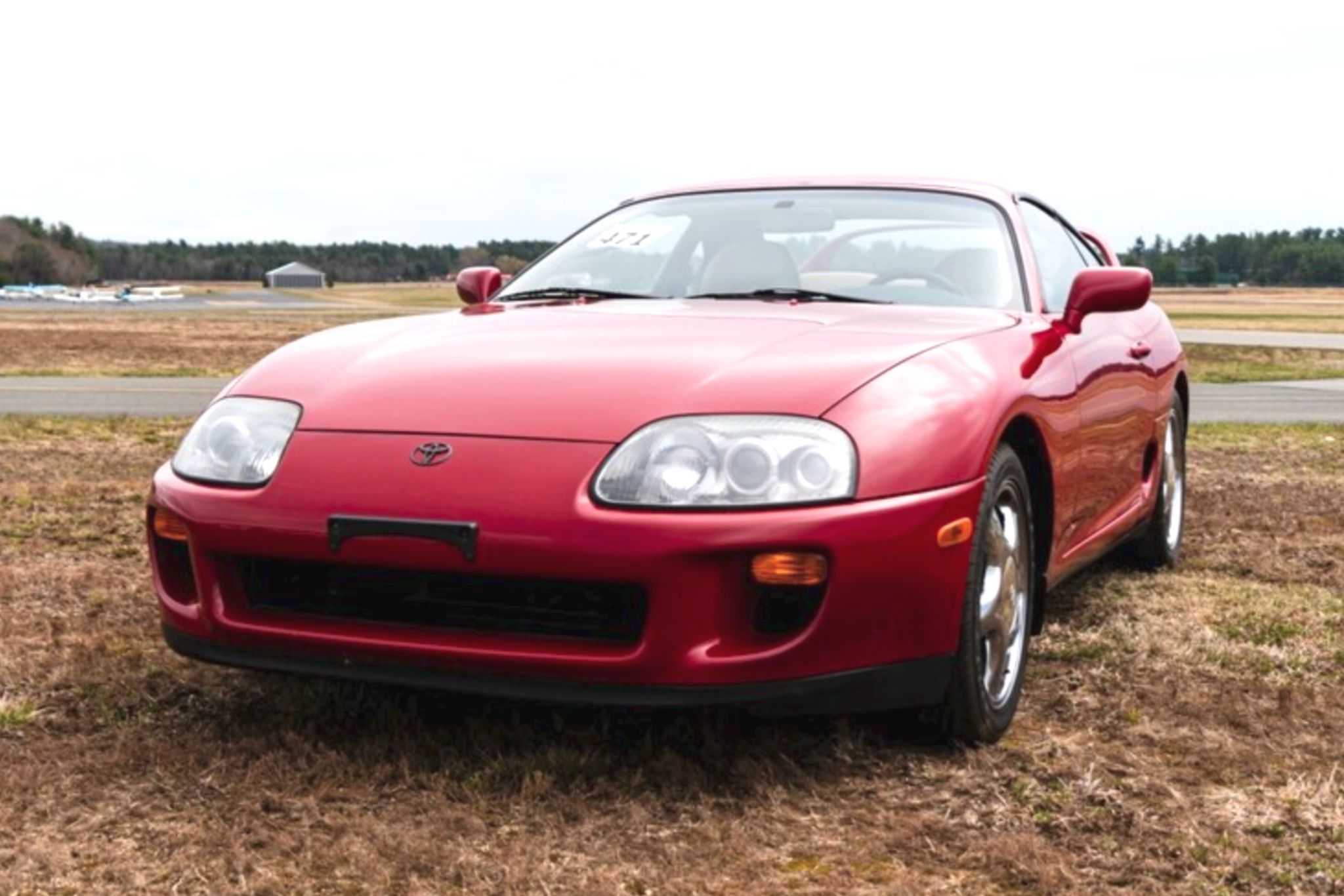 Red Toyota Supra in field