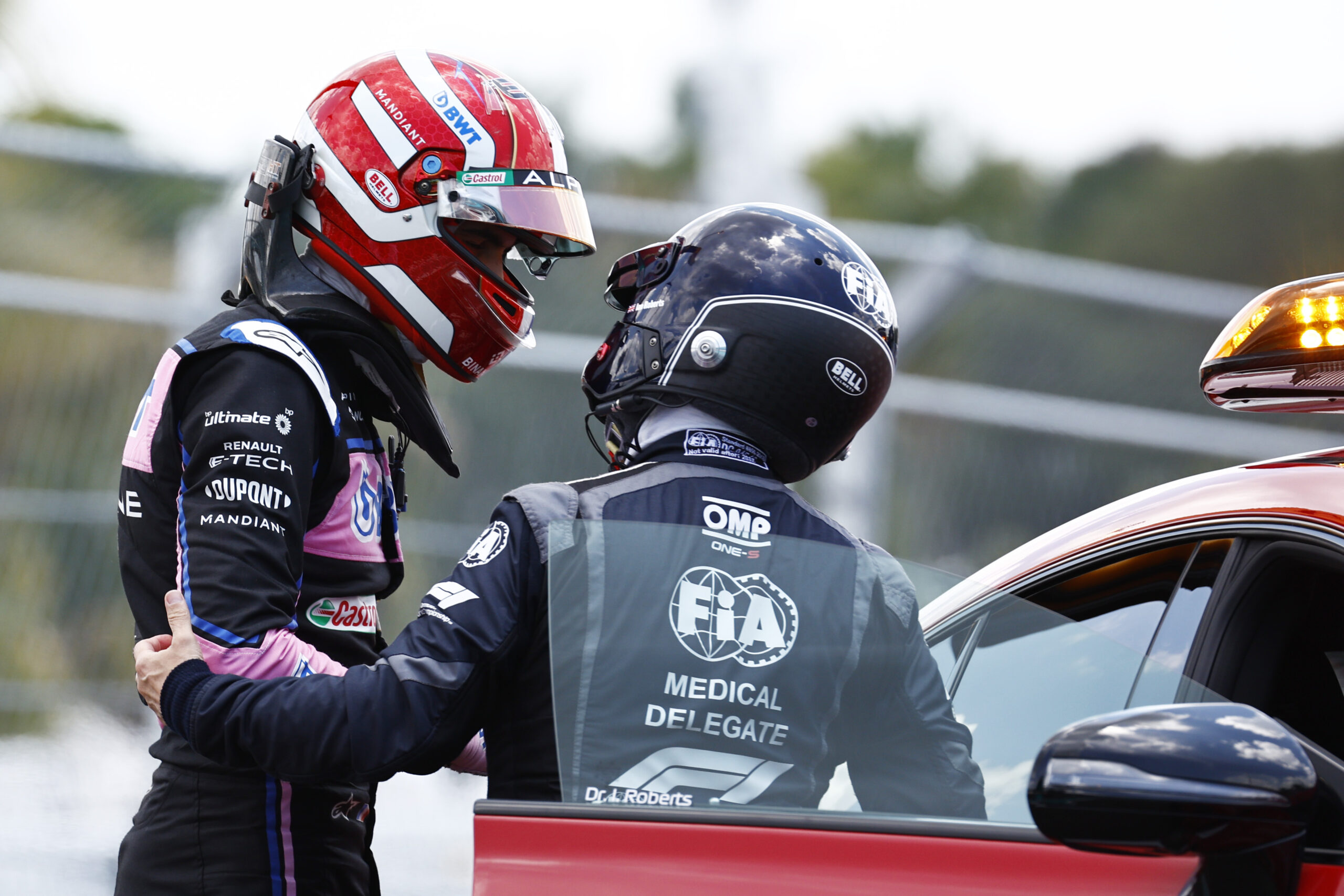 Esteban Ocon being helped into the F1 medical car by medical personnel