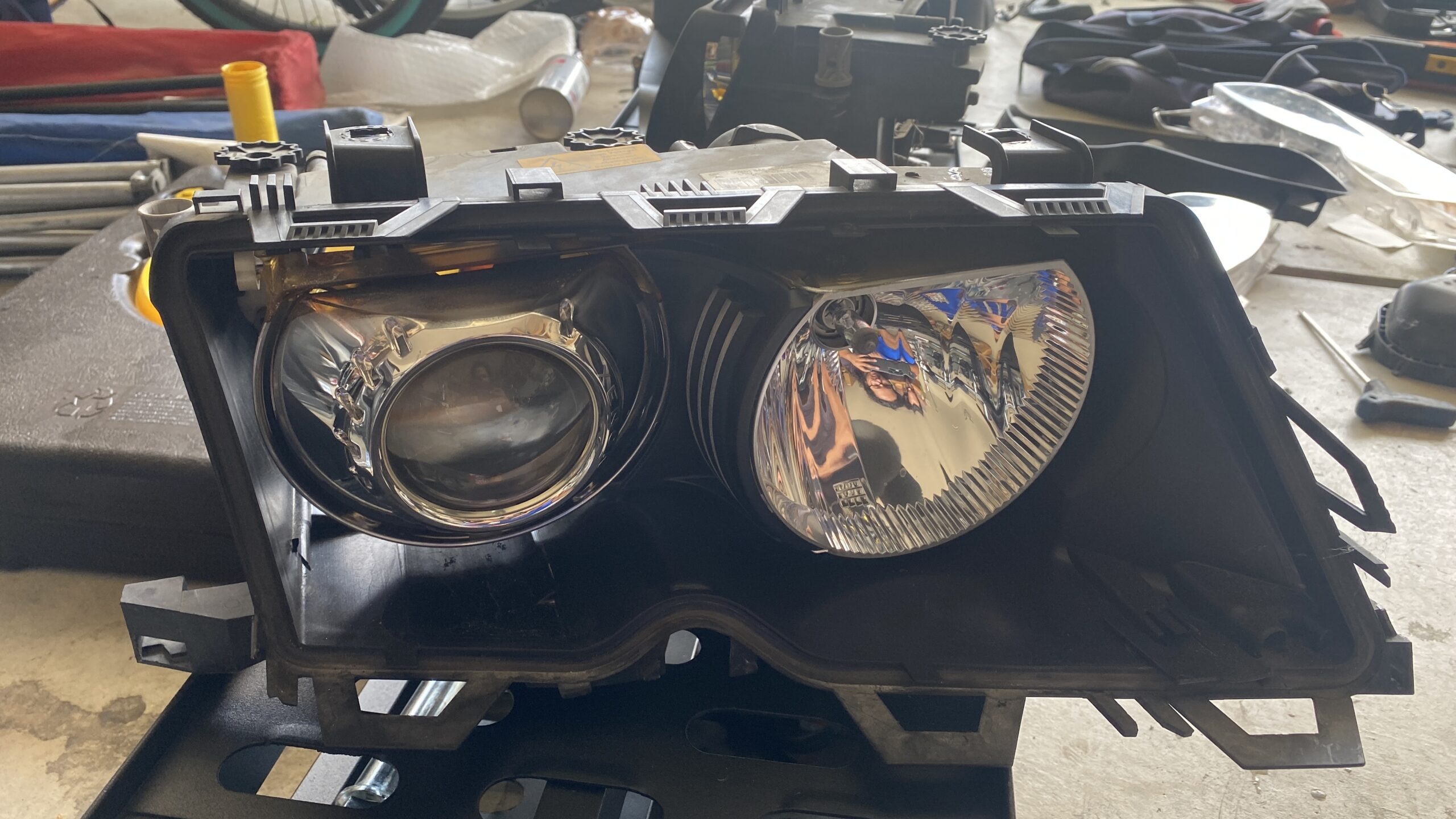 The inner headlight assembly from a 2004 BMW 330i sedan.