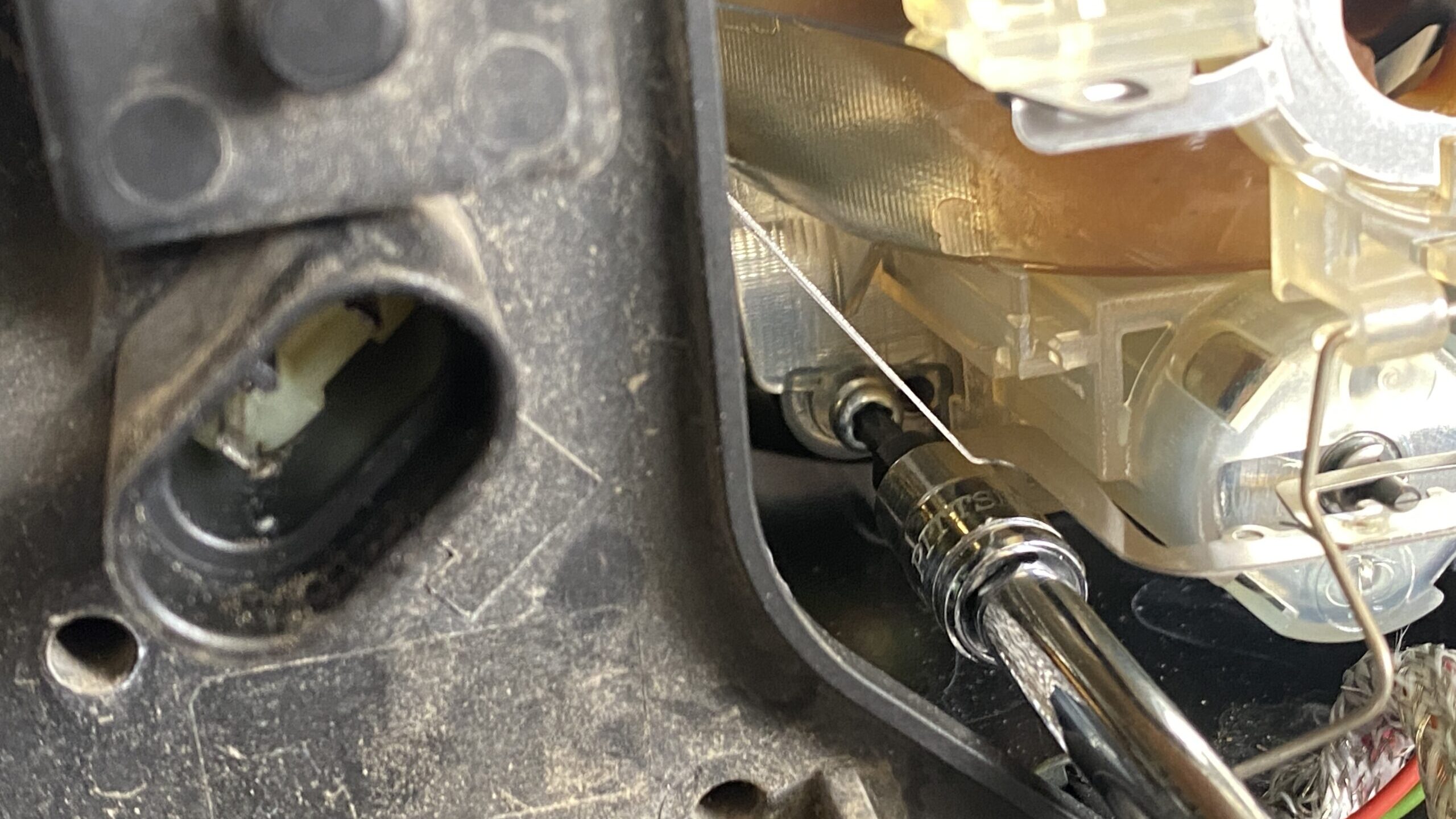 Demonstrating how to unbolt the projector of a 2004 BMW 330i.