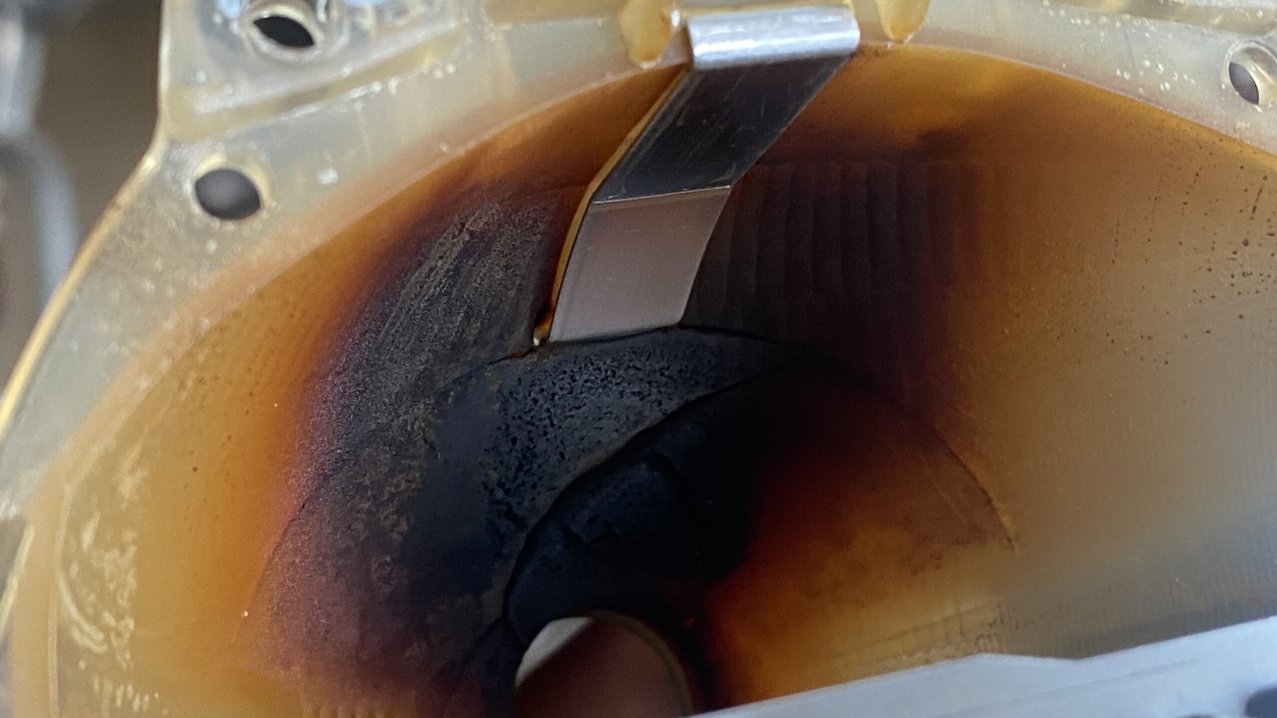 A blackened and charred headlight reflector bowl from a 2004 BMW 330i.