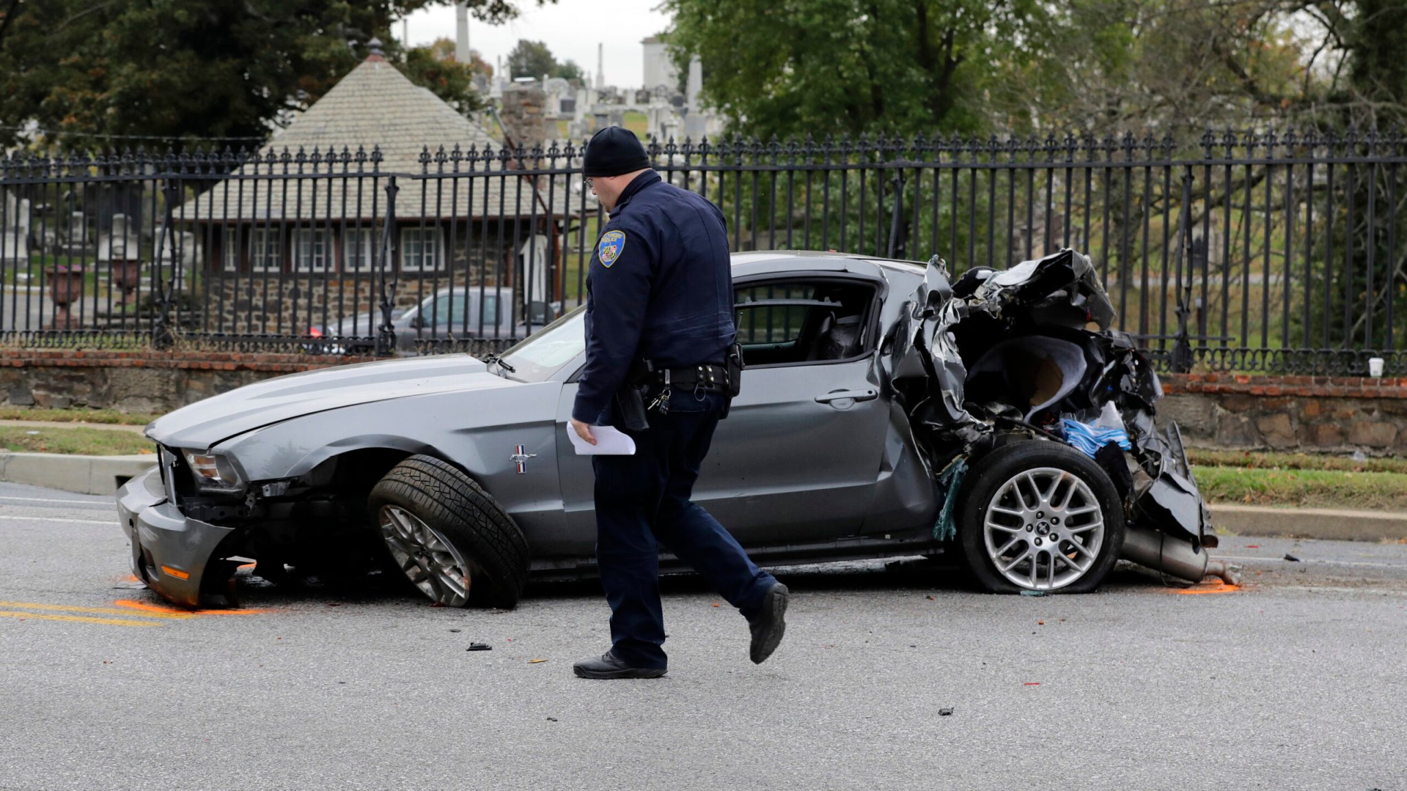 An officer walks past a car involved in a fatal crash