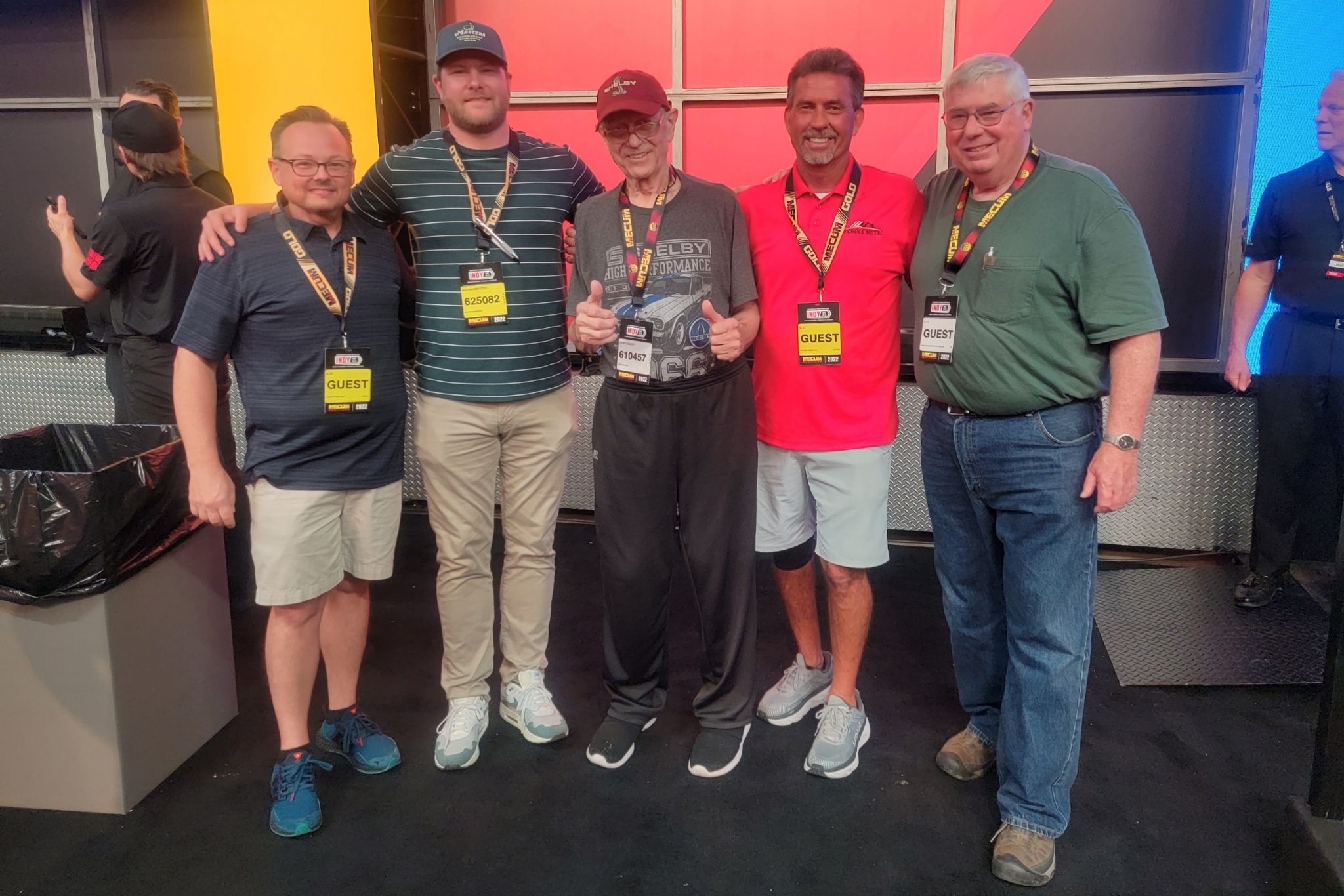 Five men standing in front of colorful background