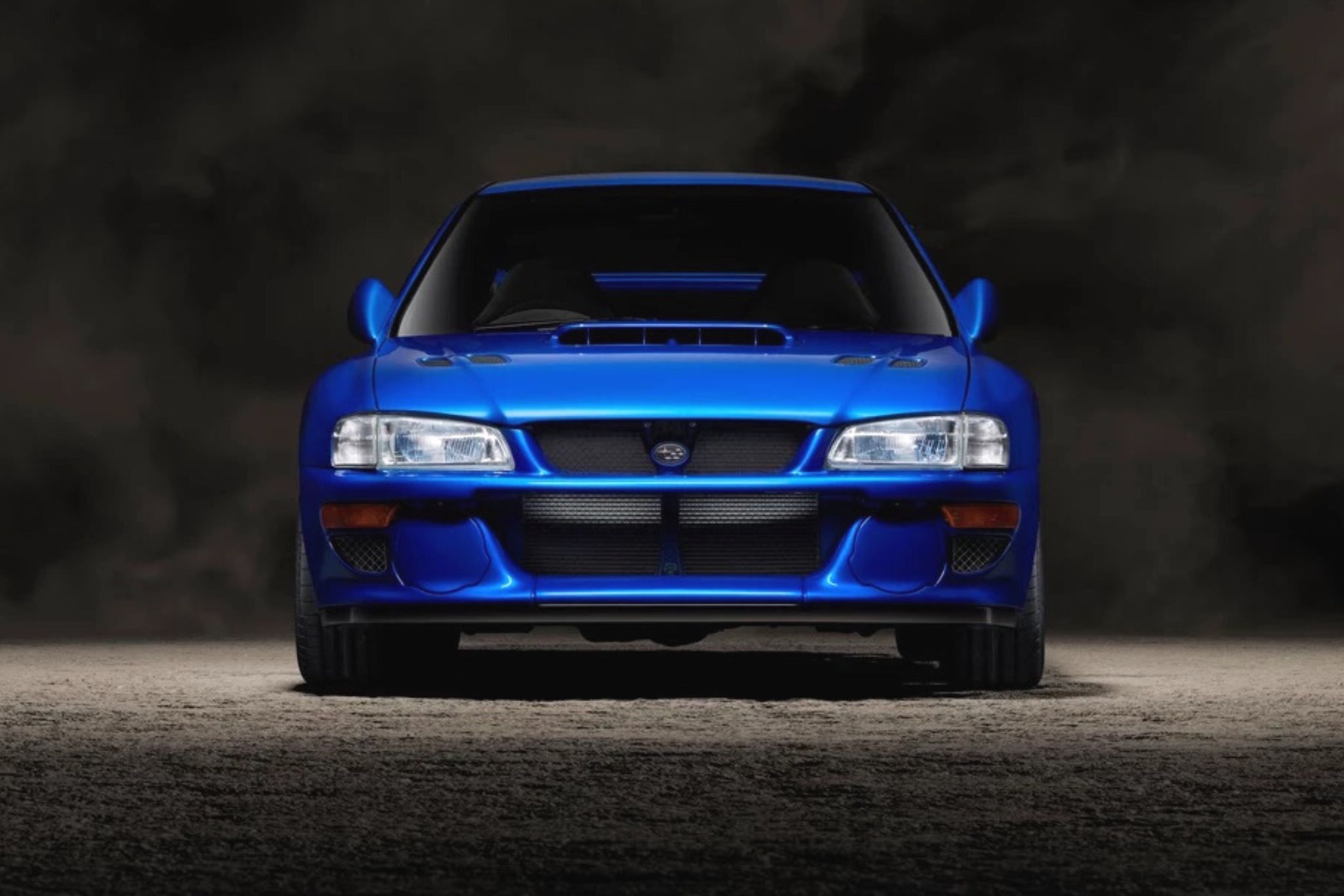 front of blue car on black background