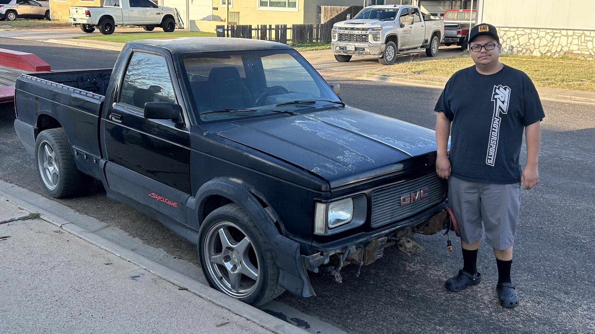 A GMC Syclone with its owner standing next to it