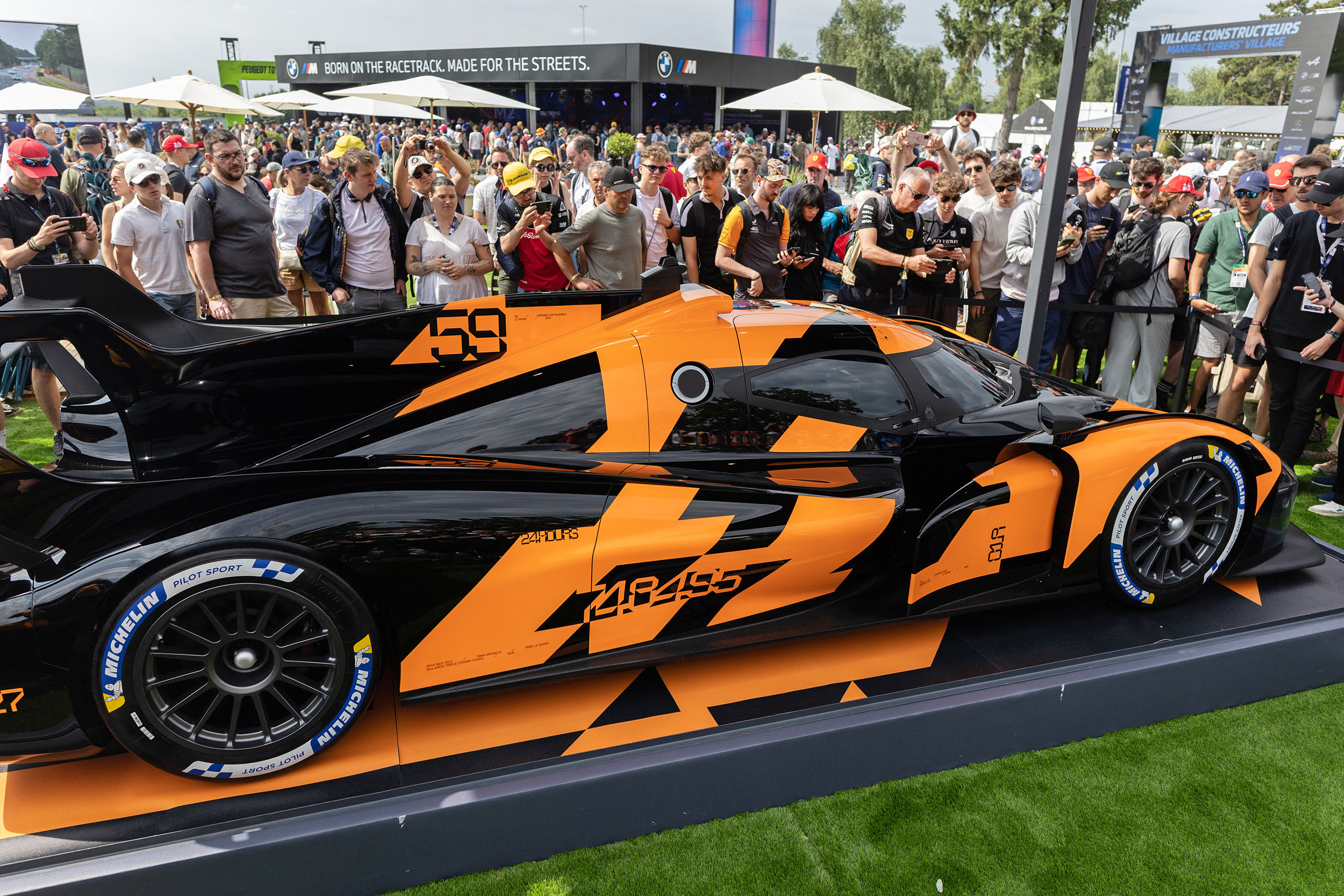 Visitors take pictures of the new McLaren prototype for 2027 on the sidelines of the Le Mans 24 hour endurance race at the Le Mans circuit, in northwestern France on June 14, 2025. (Photo by Fred TANNEAU / AFP) (Photo by FRED TANNEAU/AFP via Getty Images)