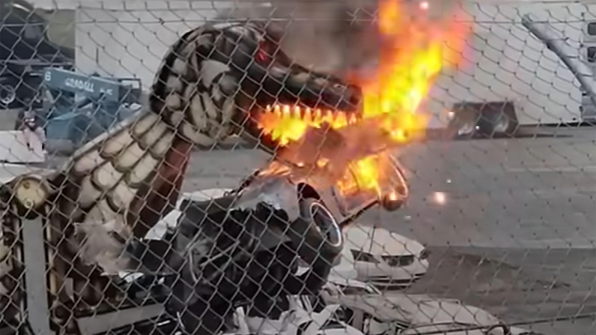 Photo of SSC Ultimate Aero being destroyed by mechanical, fire-spewing T-Rex at monster truck rally.