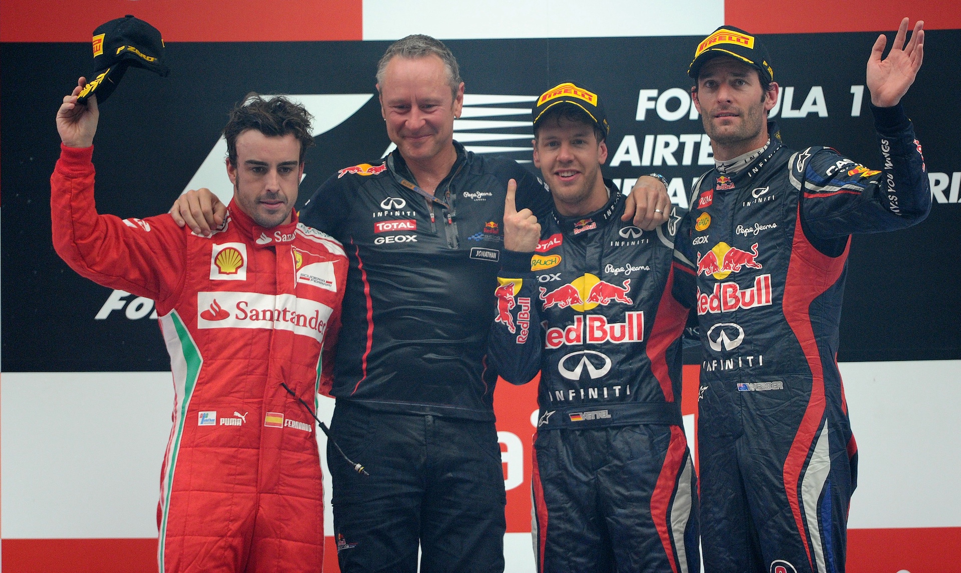 Winner Red Bull-Renault driver Sebastian Vettel of Germany (2R) poses at the podium with third-placed teammate Red Bull-Renault driver Mark Webber of Australia (R), second-placed Ferrari driver Fernando Alonso of Spain (L) and Red Bull team manager Jonathan Wheatley after victory at the Formula One Indian Grand Prix at The Buddh International circuit in Greater Noida, on the outskirts of New Delhi on October 28, 2012. AFP PHOTO/ PRAKASH SINGH (Photo credit should read PRAKASH SINGH/AFP via Getty Images)