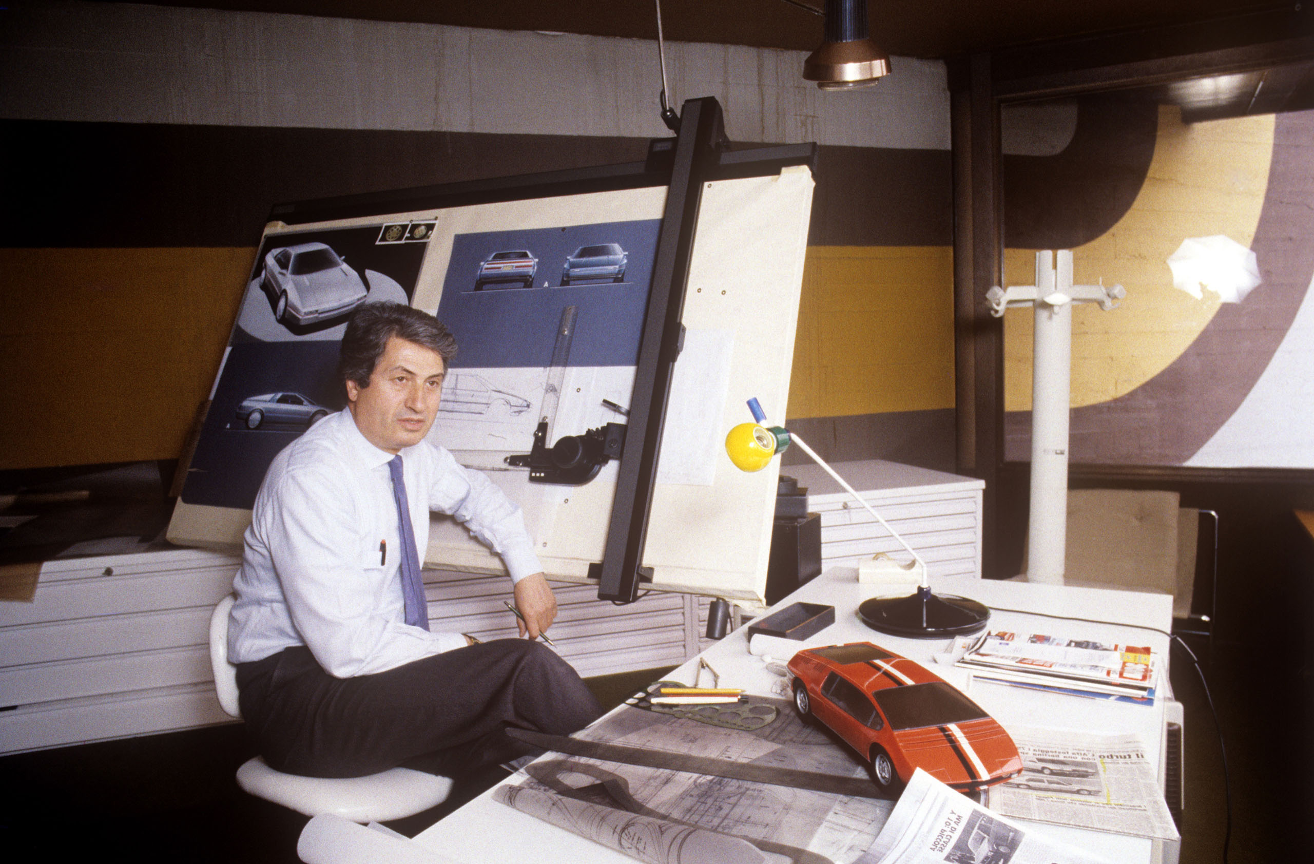 Italian designer Giorgetto Giugiaro sitting in his office in front of a drawing board. 1987. (Photo by Adriano Alecchi/Mondadori via Getty Images)