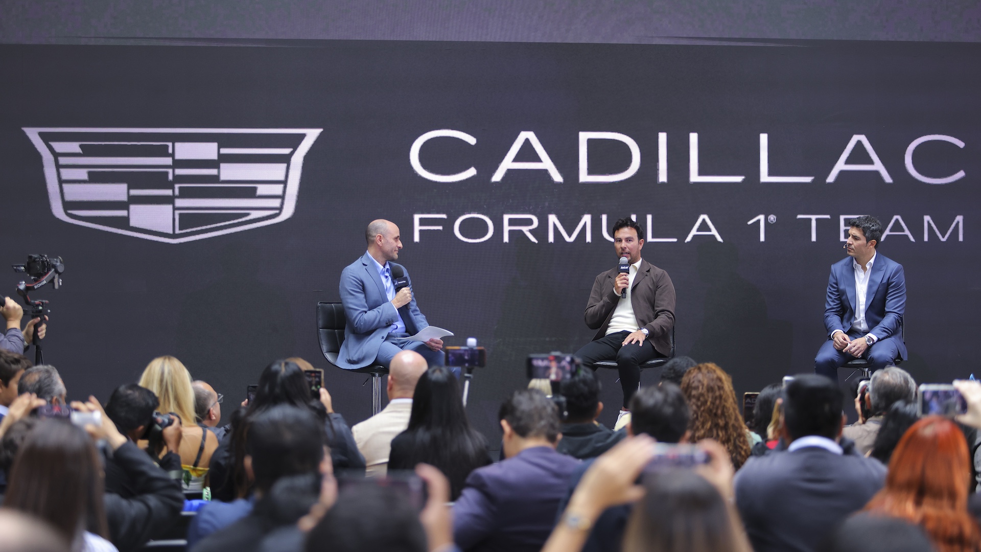 MEXICO CITY, MEXICO - AUGUST 27: Driver Sergio Perez (C) speaks during a press conference at Teatro Telcel on August 27, 2025 in Mexico City, Mexico. Sergio "Checo" Perez will join Cadillac Formula 1 Team in 2026 as one of the drivers alongside Valtteri Botas. Perez has raced for 14 seasons as part of Sauber, Force India, Racing Point and Red Bull teams. (Photo by Agustin Cuevas/Getty Images)