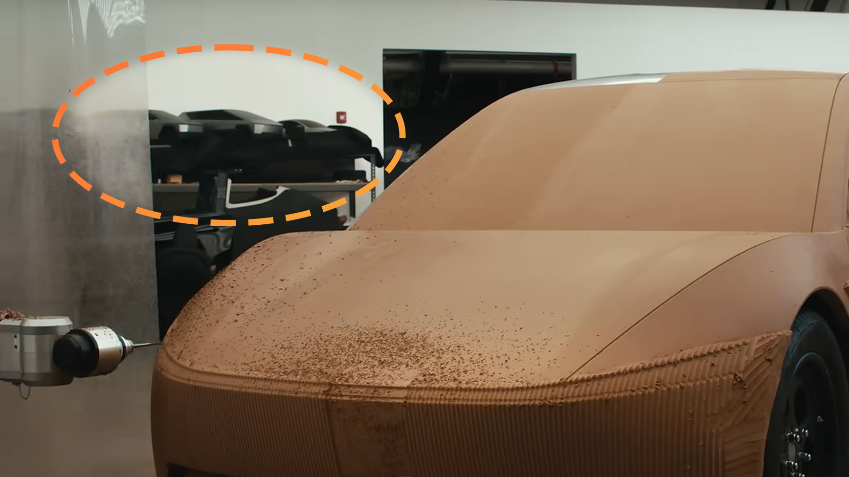 Tesla video screenshot with scale model of Cybertruck-like SUV circled