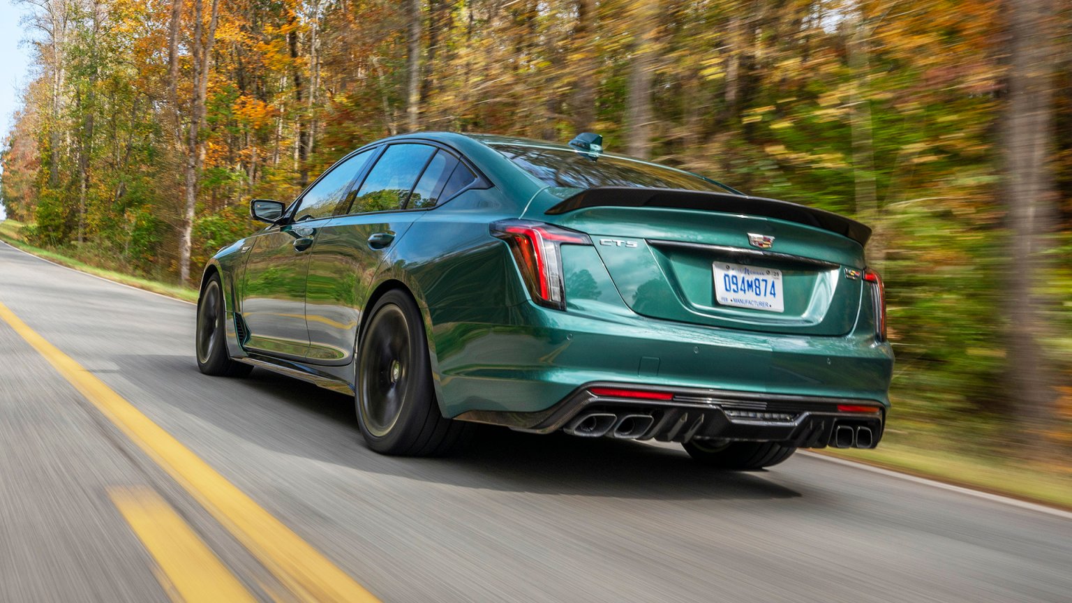 Rear view of the 2026 Cadillac CT5-V Blackwing Precision Package in Typhoon Metallic driving on a road.