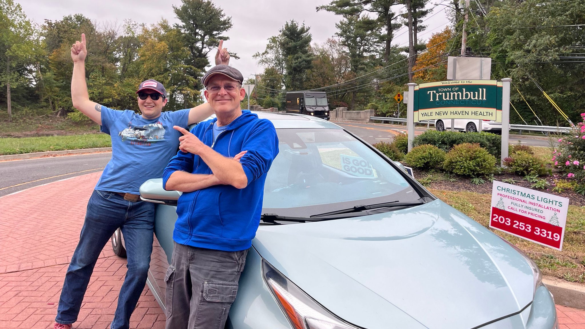 Jake Dwinell and Jay Roberts pose after completing a five-hour run in a roundabout, with the Toyota Prius used for the drive.