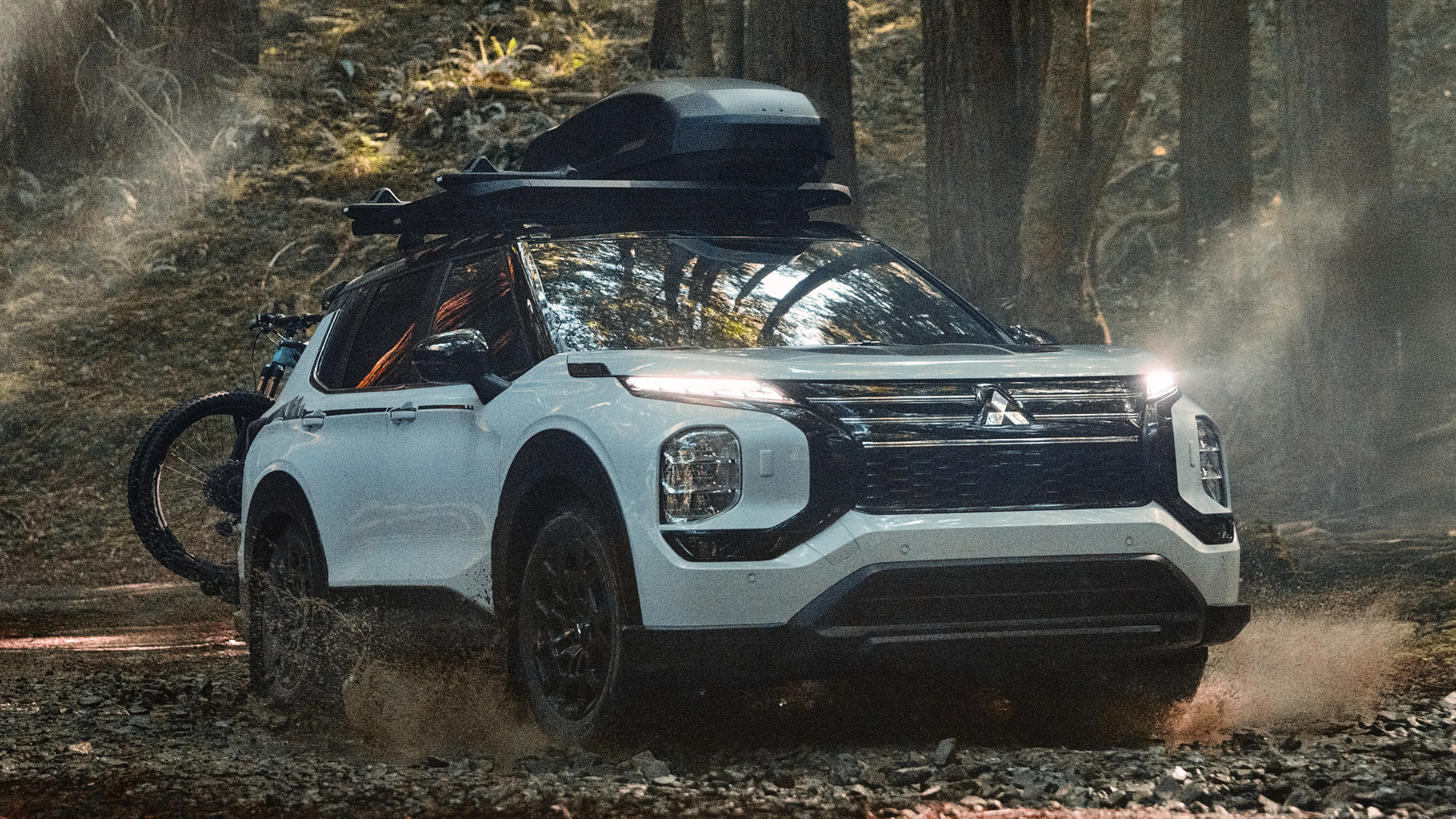 Mitsubishi Outlander Trail Edition SUV splashing through mud.