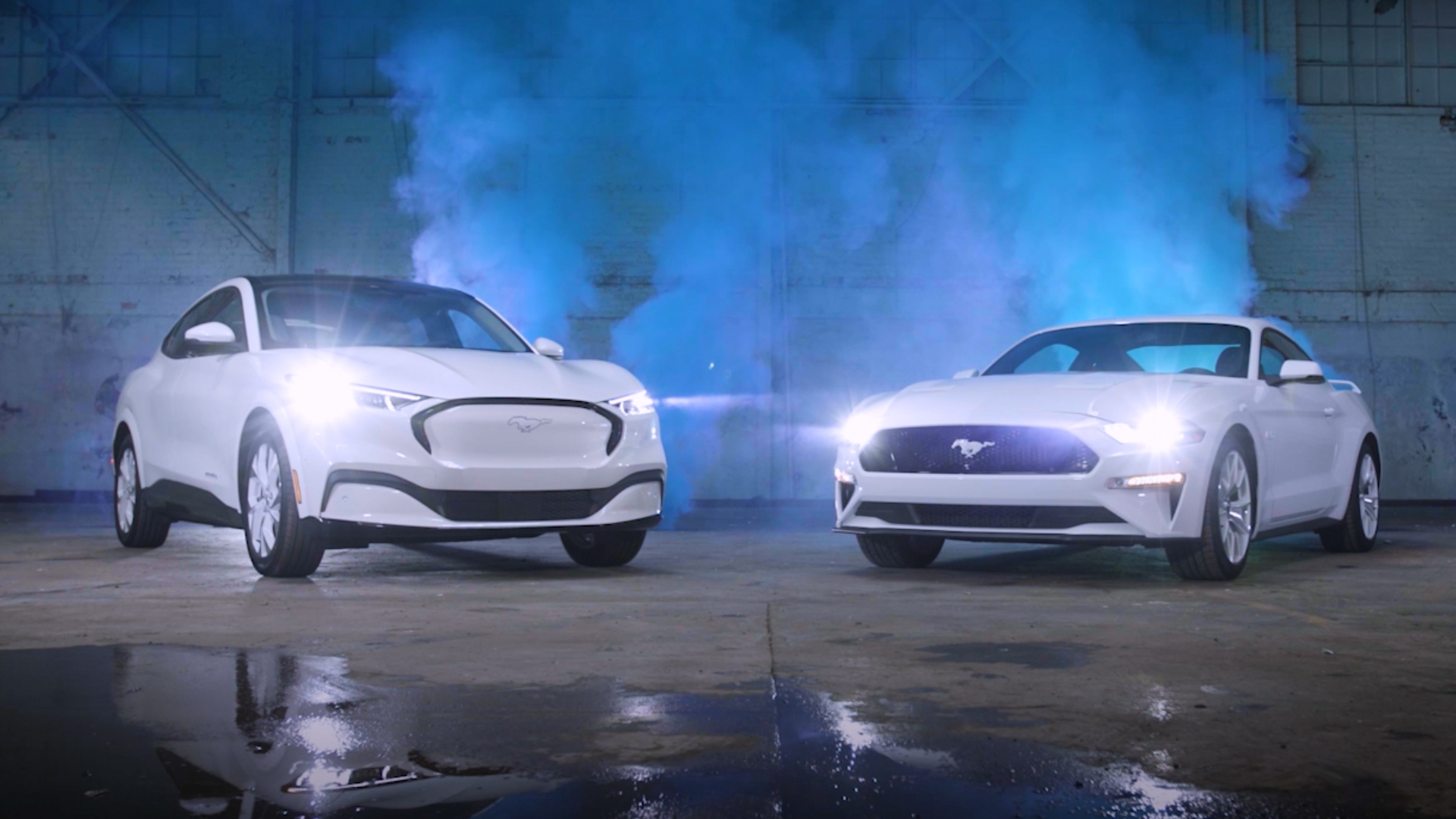 Ford Mustang Mach-E with a traditional Ford Mustang coupe, both in white.