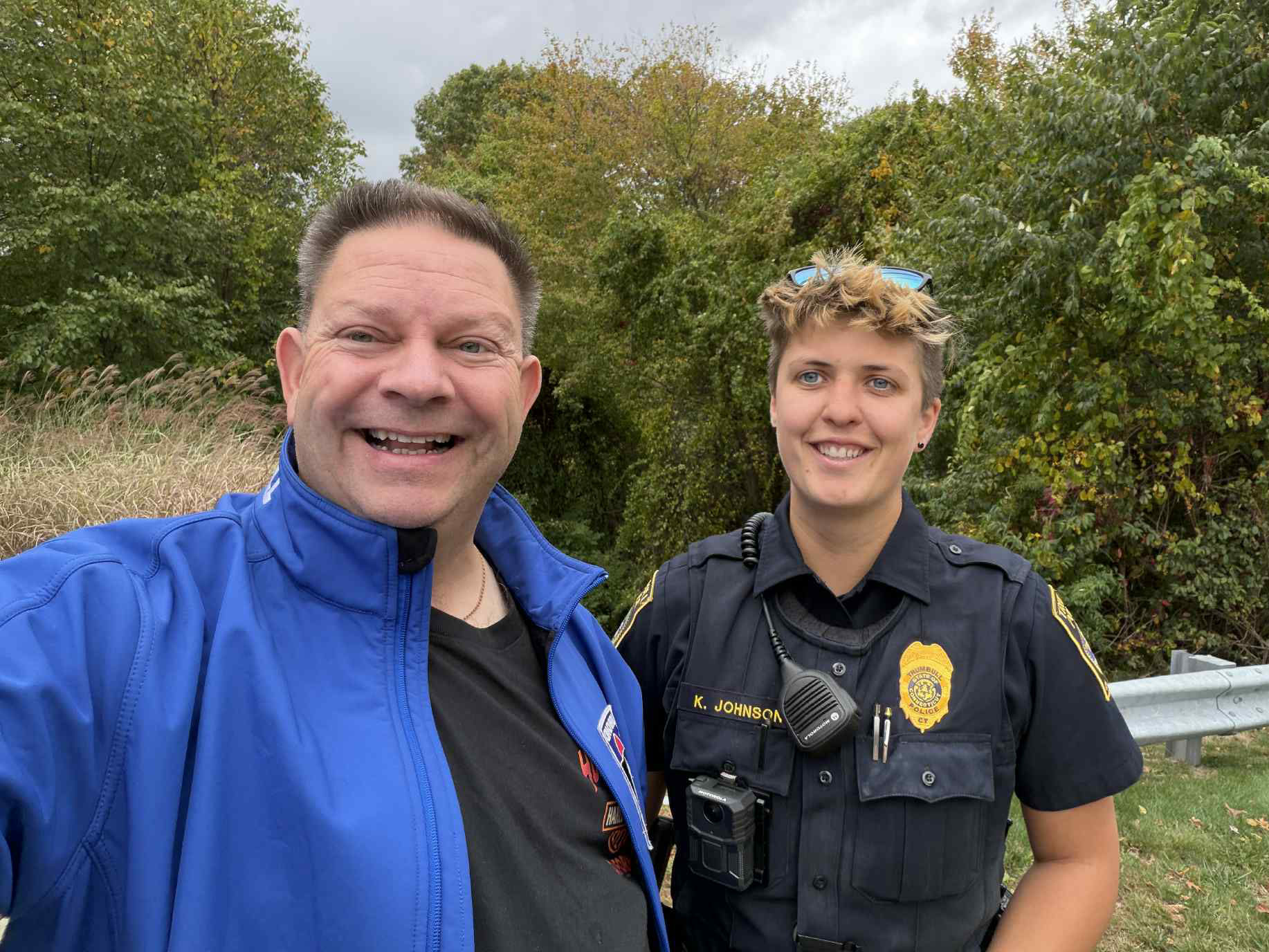 Man poses with police officer for selfie