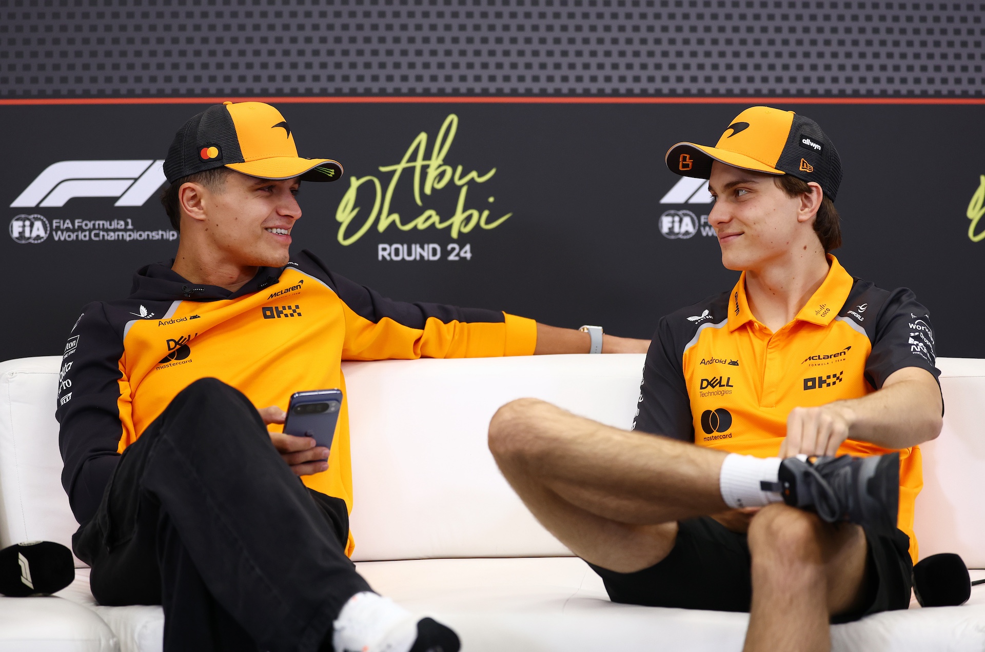 ABU DHABI, UNITED ARAB EMIRATES - DECEMBER 04: Lando Norris of Great Britain and McLaren and Oscar Piastri of Australia and McLaren talk in the Drivers Press Conference during previews ahead of the F1 Grand Prix of Abu Dhabi at Yas Marina Circuit on December 04, 2025 in Abu Dhabi, United Arab Emirates. (Photo by Clive Rose/Getty Images)