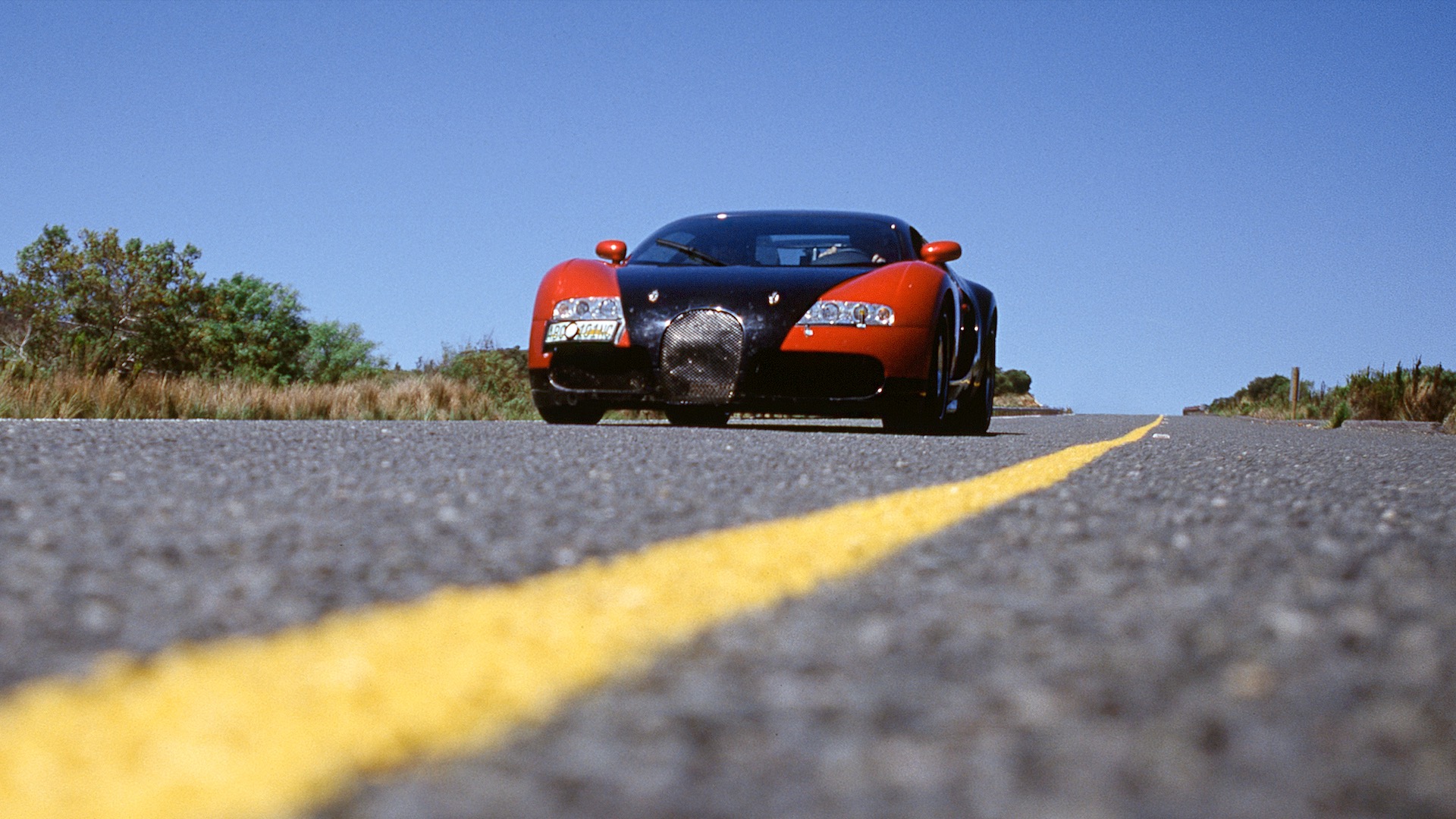 Front view of a red and black Bugatti Veyron prototype.