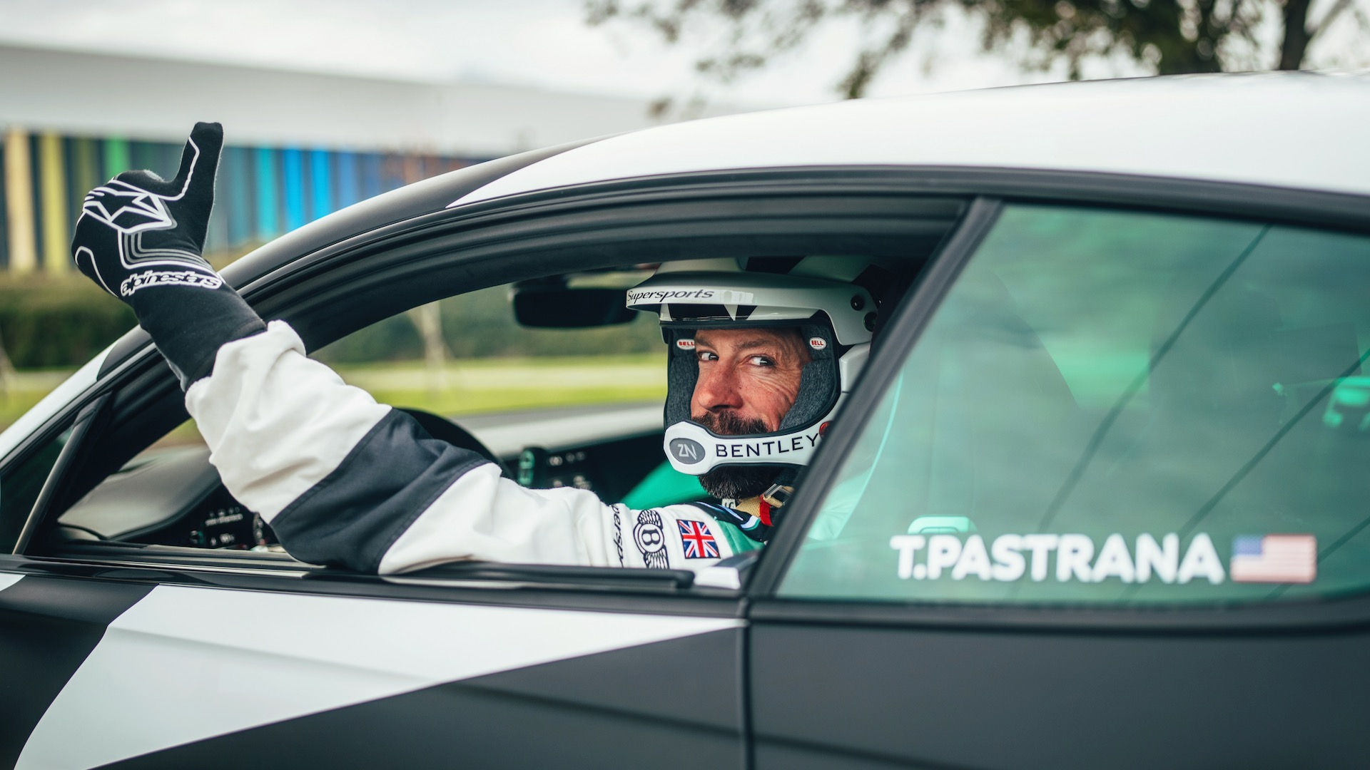 Travis Pastrana in a Bentley racing suit and helmet.