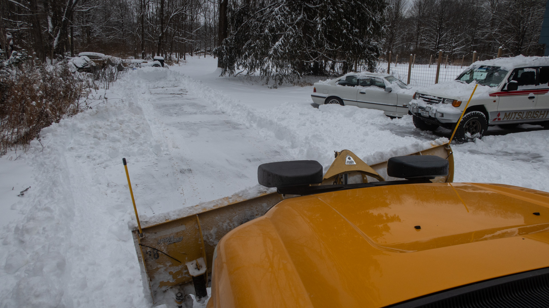 Plowing carefully to steer clear of cars.