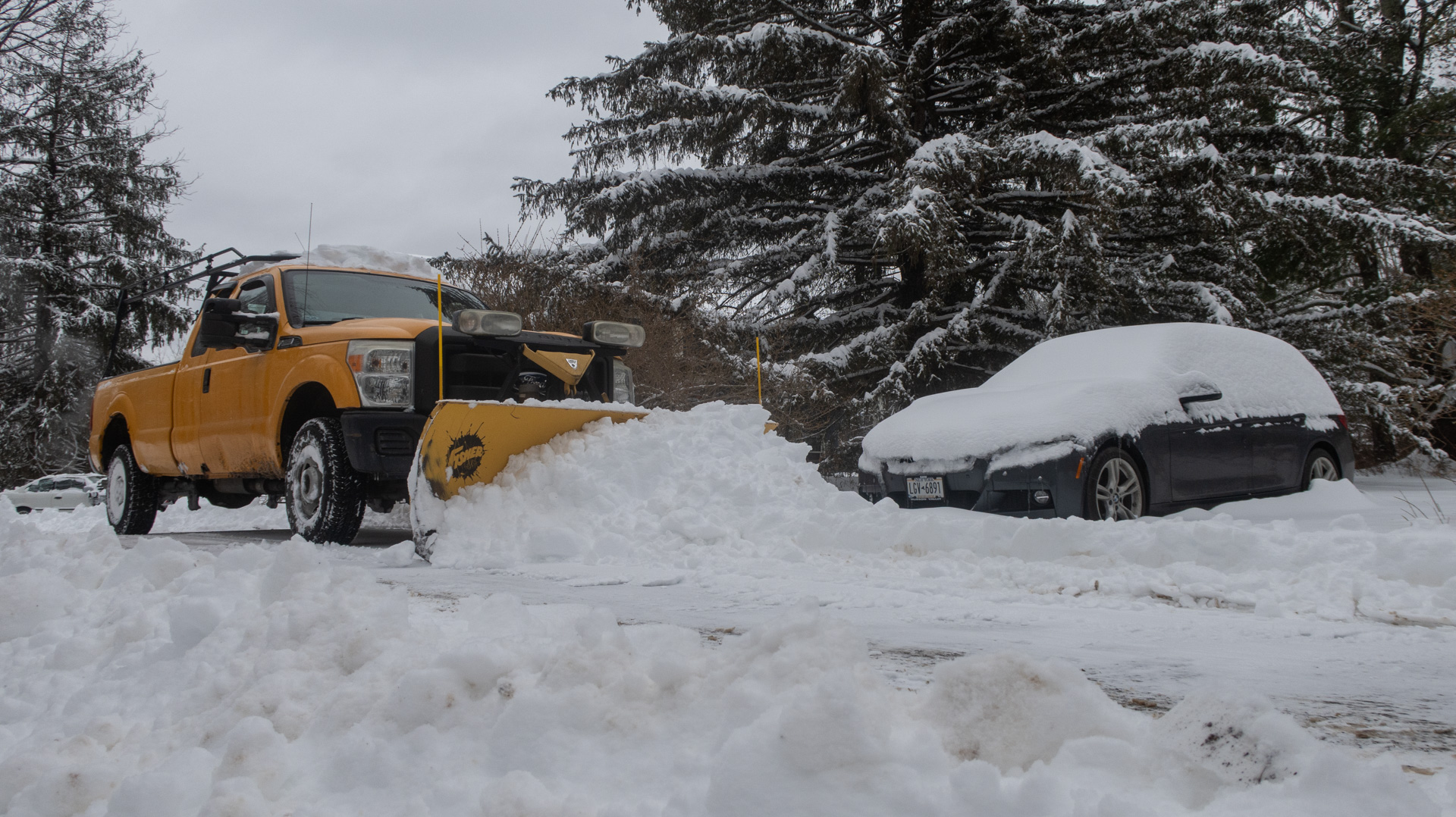A plow truck extracting BMWs from the snow.