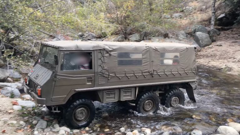 Pinzgauer EV conversion driving through a stream.