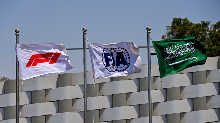 The flags of the Formula One (L), the Federation Internationale de l'Automobile (C) and Saudi Arabia (R) wave ahead of the third practice session ahead of the 2022 Saudi Arabia Formula One Grand Prix at the Jeddah Corniche Circuit on March 26, 2022. (Photo by ANDREJ ISAKOVIC / AFP) (Photo by ANDREJ ISAKOVIC/AFP via Getty Images)