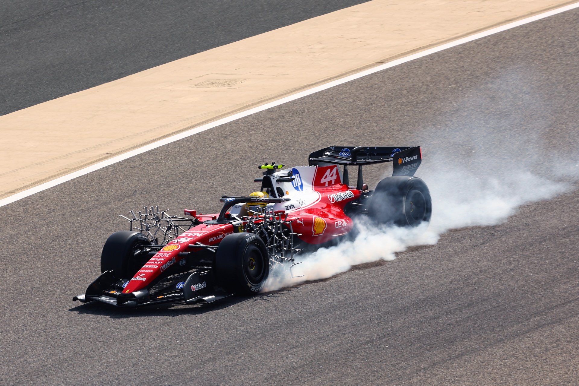 BAHRAIN, BAHRAIN - FEBRUARY 11: Lewis Hamilton of Great Britain driving the (44) Scuderia Ferrari SF-26 locks a wheel under braking during day one of F1 Testing at Bahrain International Circuit on February 11, 2026 in Bahrain, Bahrain. (Photo by Joe Portlock/Getty Images)
