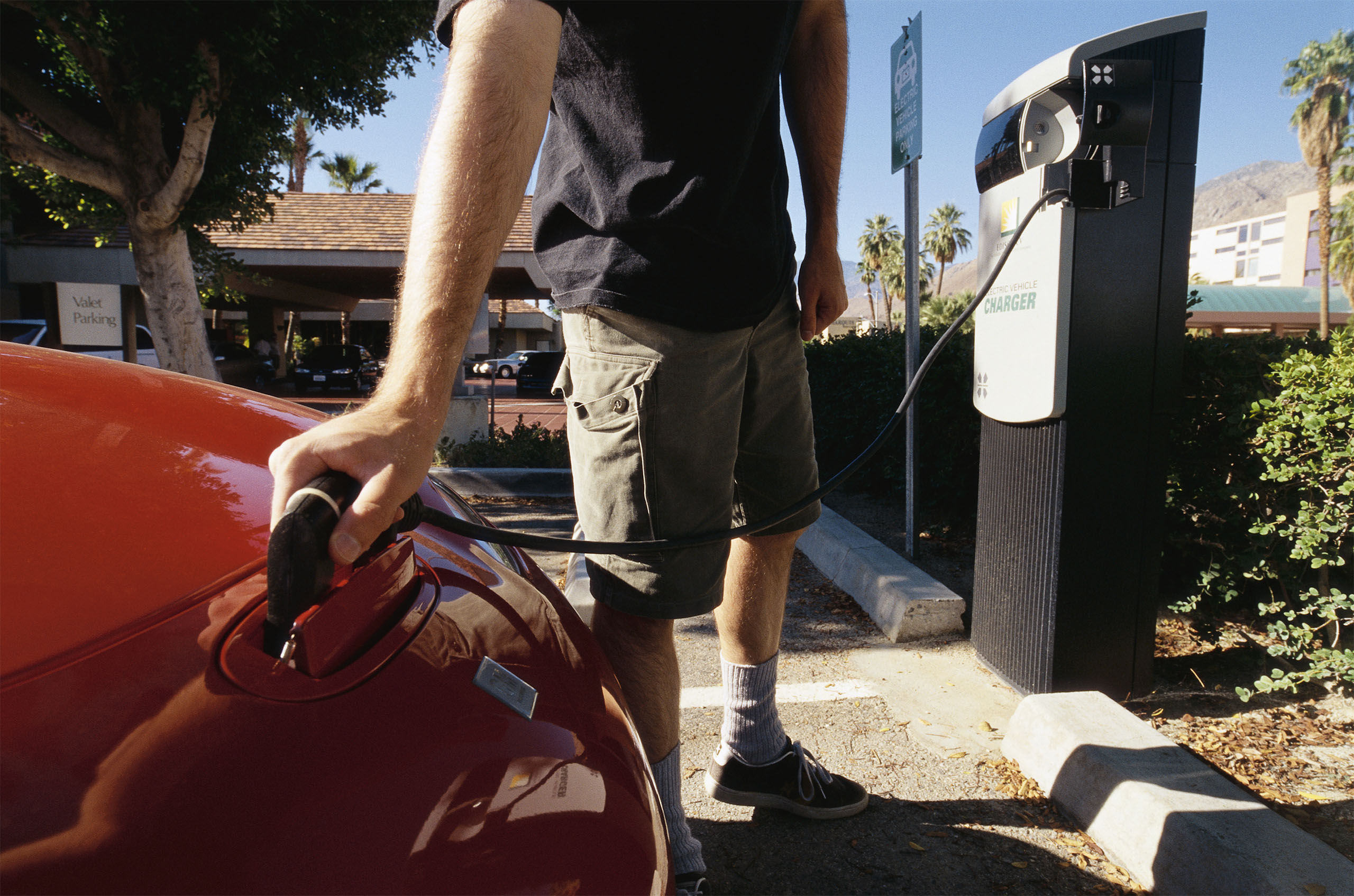 A man recharges General Motors' environmentally friendly car, the EV1 (Electric Vehicle 1). (Photo by David Butow/Corbis via Getty Images)