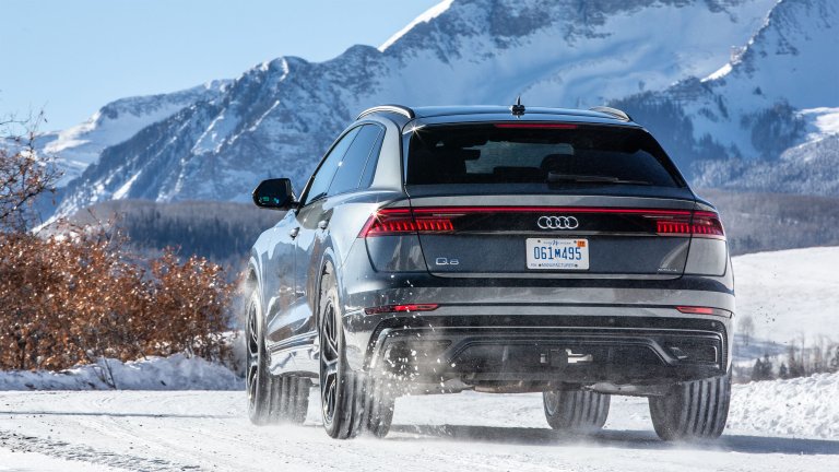 Audi Q8 driving on snow, rear view.