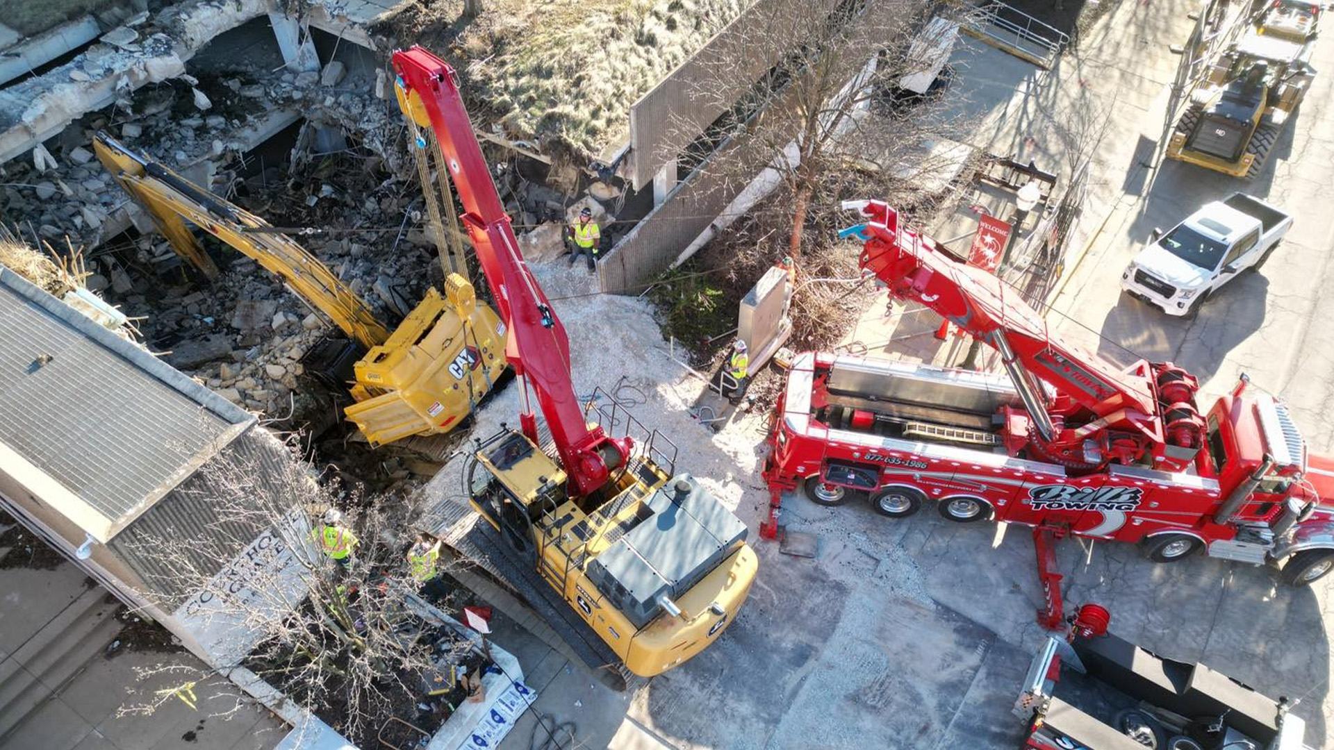 Century M100 wrecker and John Deere 470RR recover excavator that fell through a parking garage