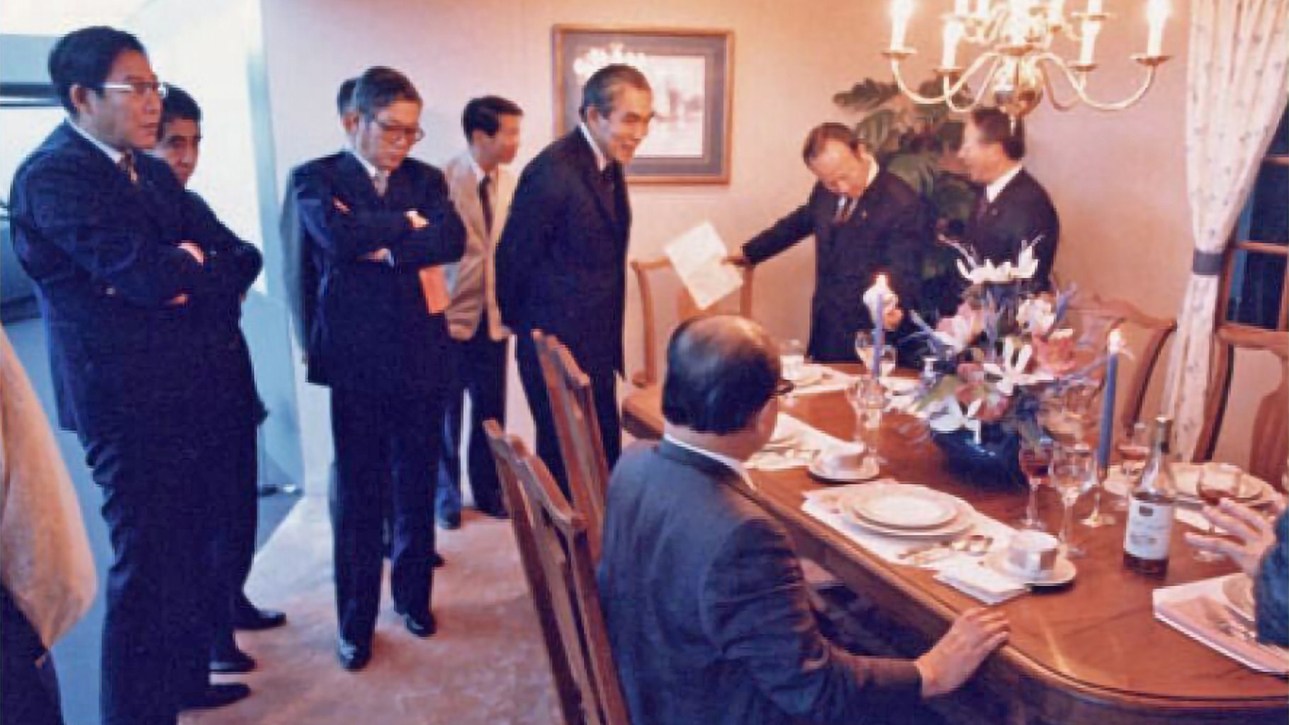 Toyota executives, including former president Hiroshi Okuda at far left, survey CALTY's mock American dining room in 1986.
